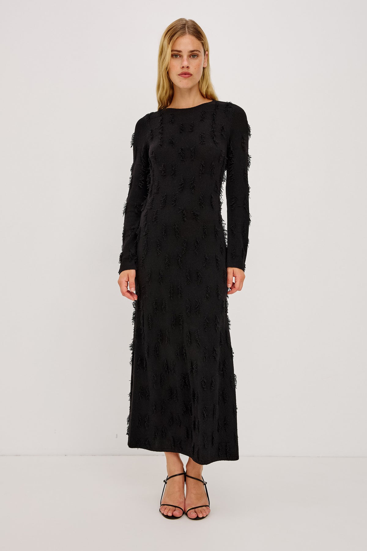 Sulma Maxi Dress Knit in Soft Fine-Gauge Yarn With Alover Fringe, Slim Fit Through Bodice and Long Sleeves, and A-Line Skirt in Black Colorway -Front Full Body View Featured on Model.