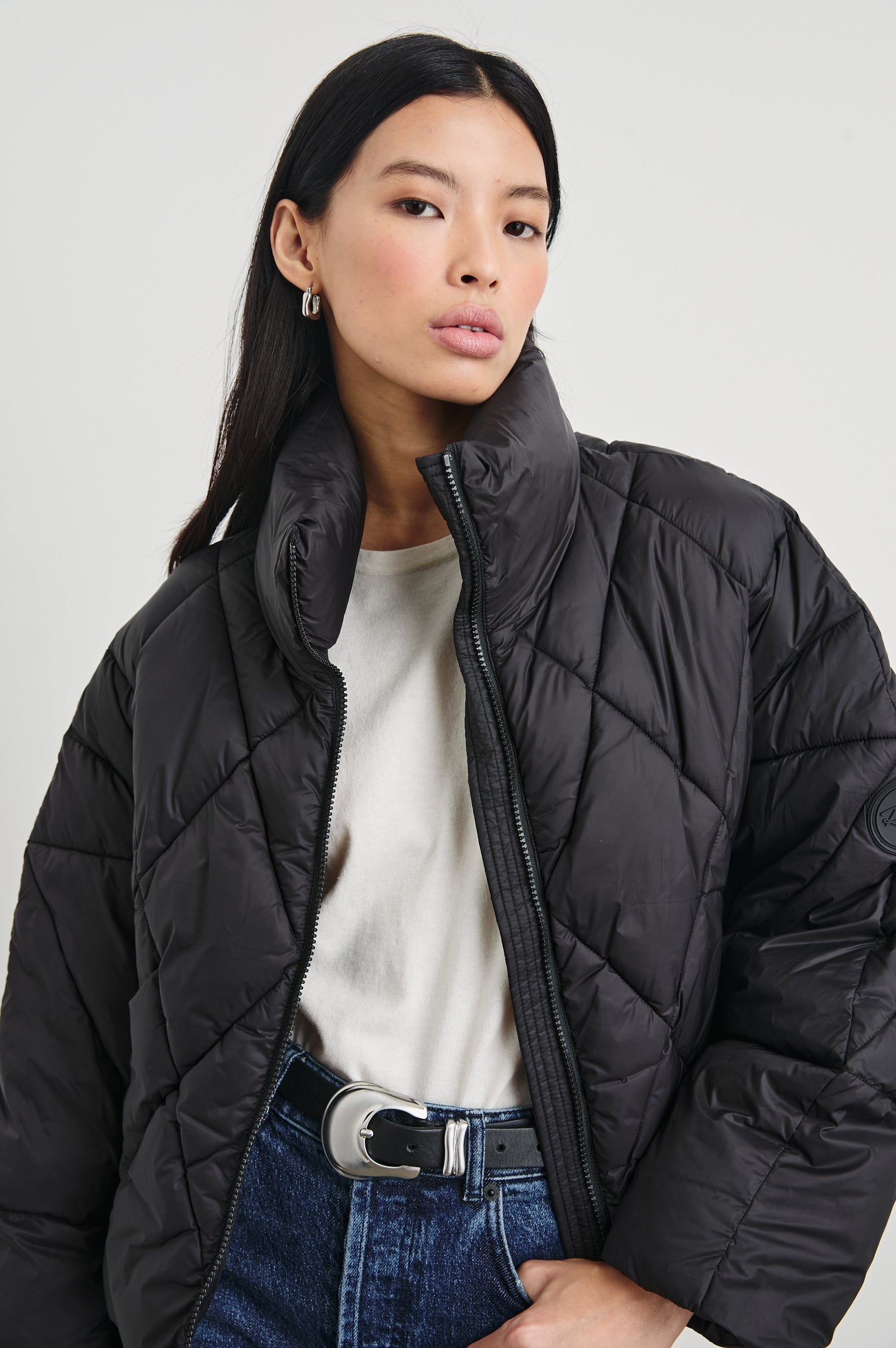 Summit Cropped Puffer Jacket with a Mid-Neck Collar, Two Pockets and a Rails Logo on the Arm in Black Colorway - Front View Featured on Model