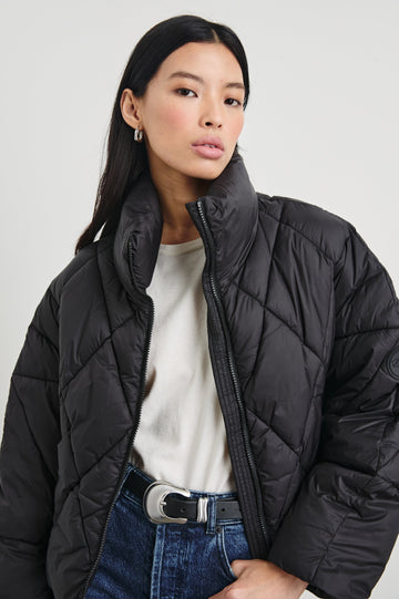 Summit Cropped Puffer Jacket with a Mid-Neck Collar, Two Pockets and a Rails Logo on the Arm in Black Colorway - Front View Featured on Model