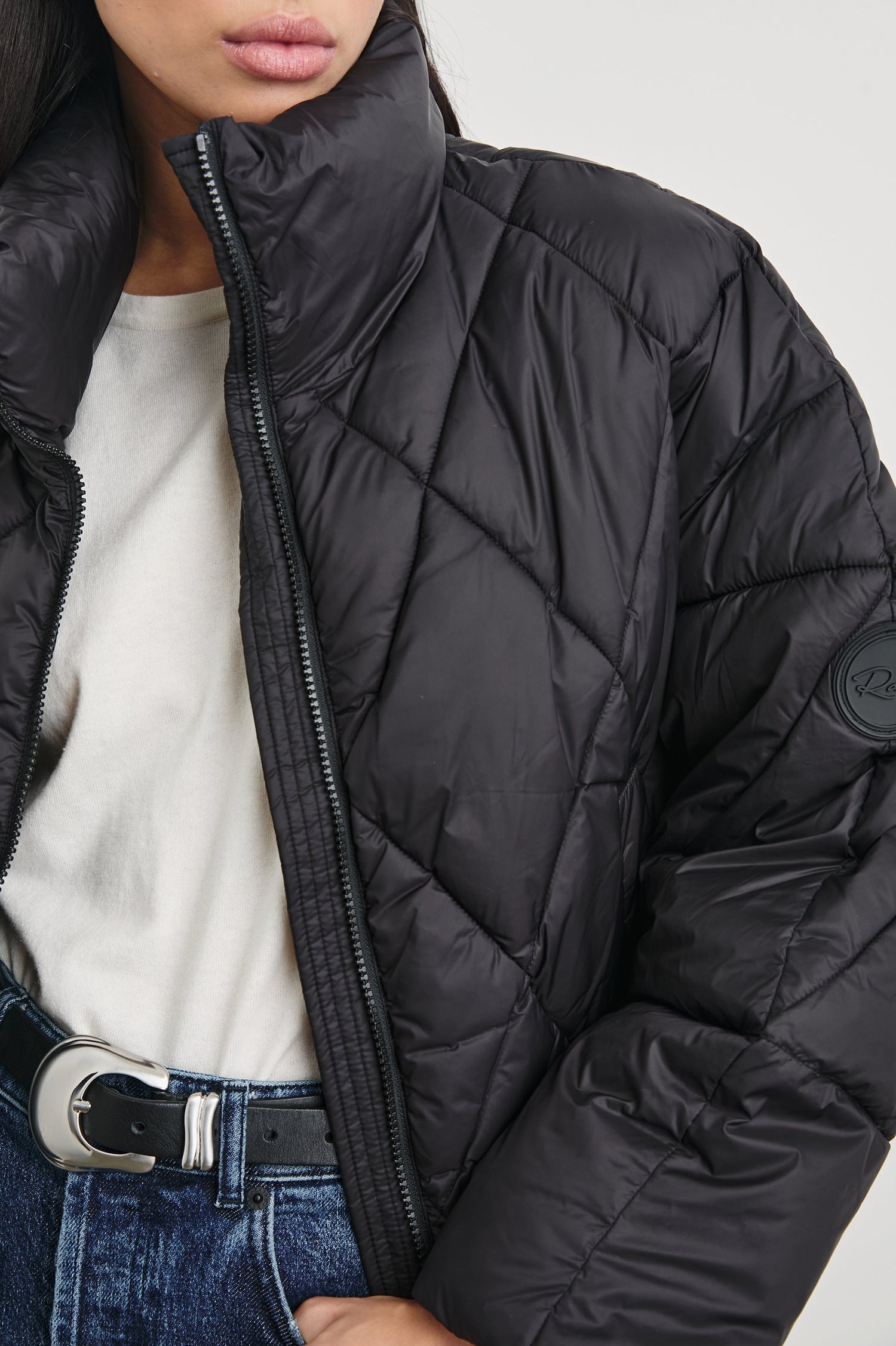 Summit Cropped Puffer Jacket with a Mid-Neck Collar, Two Pockets and a Rails Logo on the Arm in Black Colorway - Front View Featured on Model