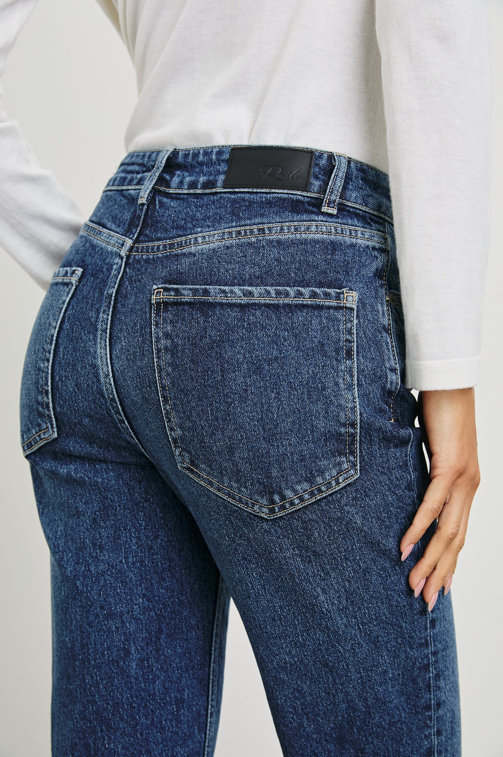 Sunset Crop Slim Fare Jeans with Belt Loops, Two Front Pockets plus a Coin Pocket and Two Back Patch Pockets in Collegiate Blue Colorway - Back View Featured on Model