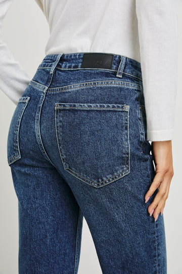 Sunset Crop Slim Fare Jeans with Belt Loops, Two Front Pockets plus a Coin Pocket and Two Back Patch Pockets in Collegiate Blue Colorway - Back View Featured on Model