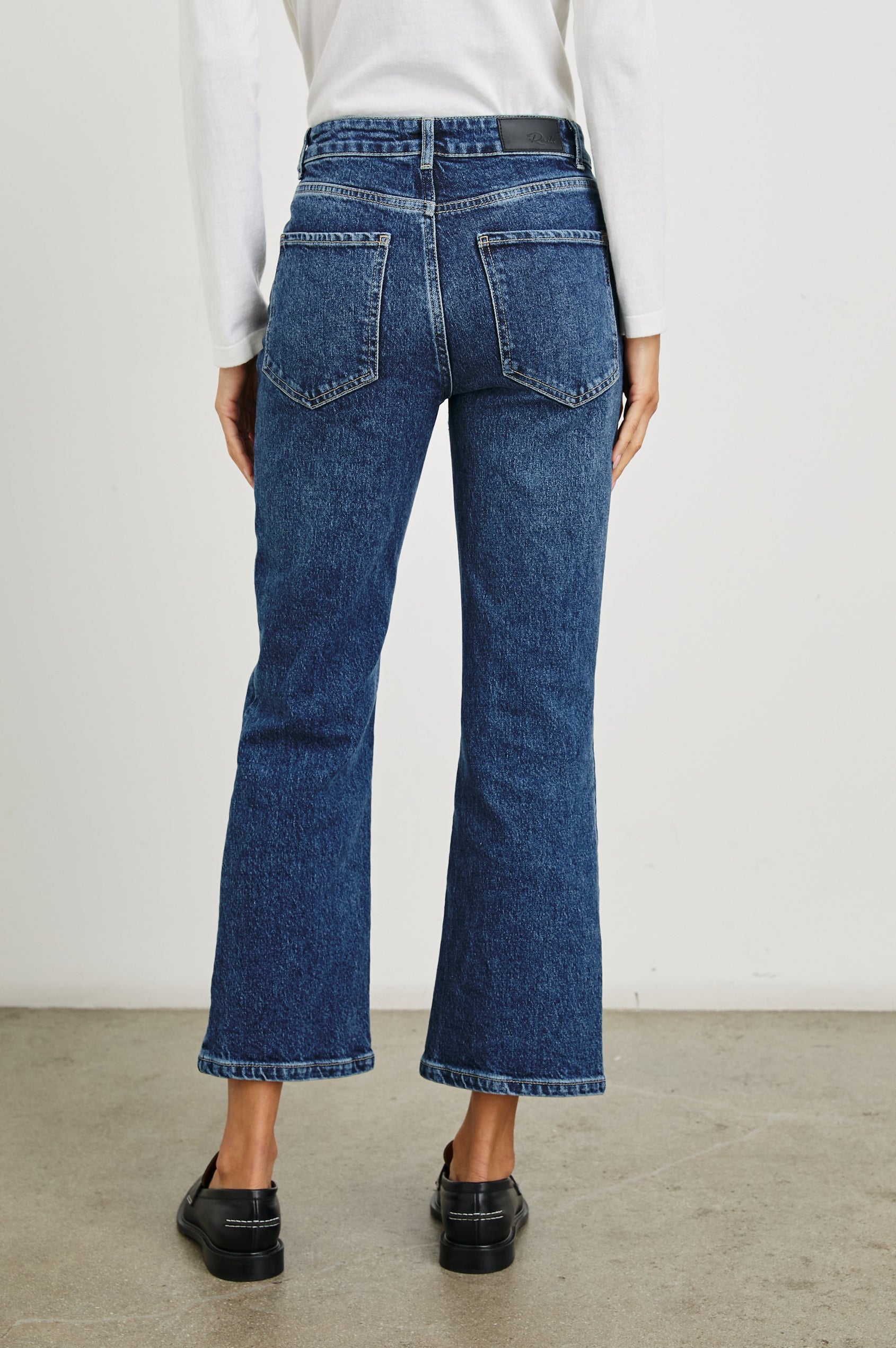 Sunset Crop Slim Fare Jeans with Belt Loops, Two Front Pockets plus a Coin Pocket and Two Back Patch Pockets in Collegiate Blue Colorway - Back View Featured on Model