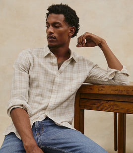 Male model wearing a plaid button down shirt with jeans