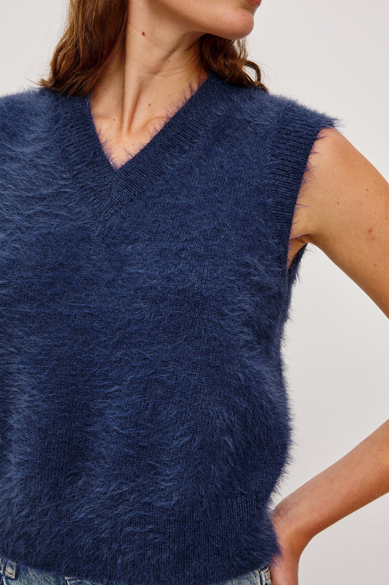 The Talli is a sweater best with a v-neck and rib trims in Navy colorway. Front detail view featured on model.