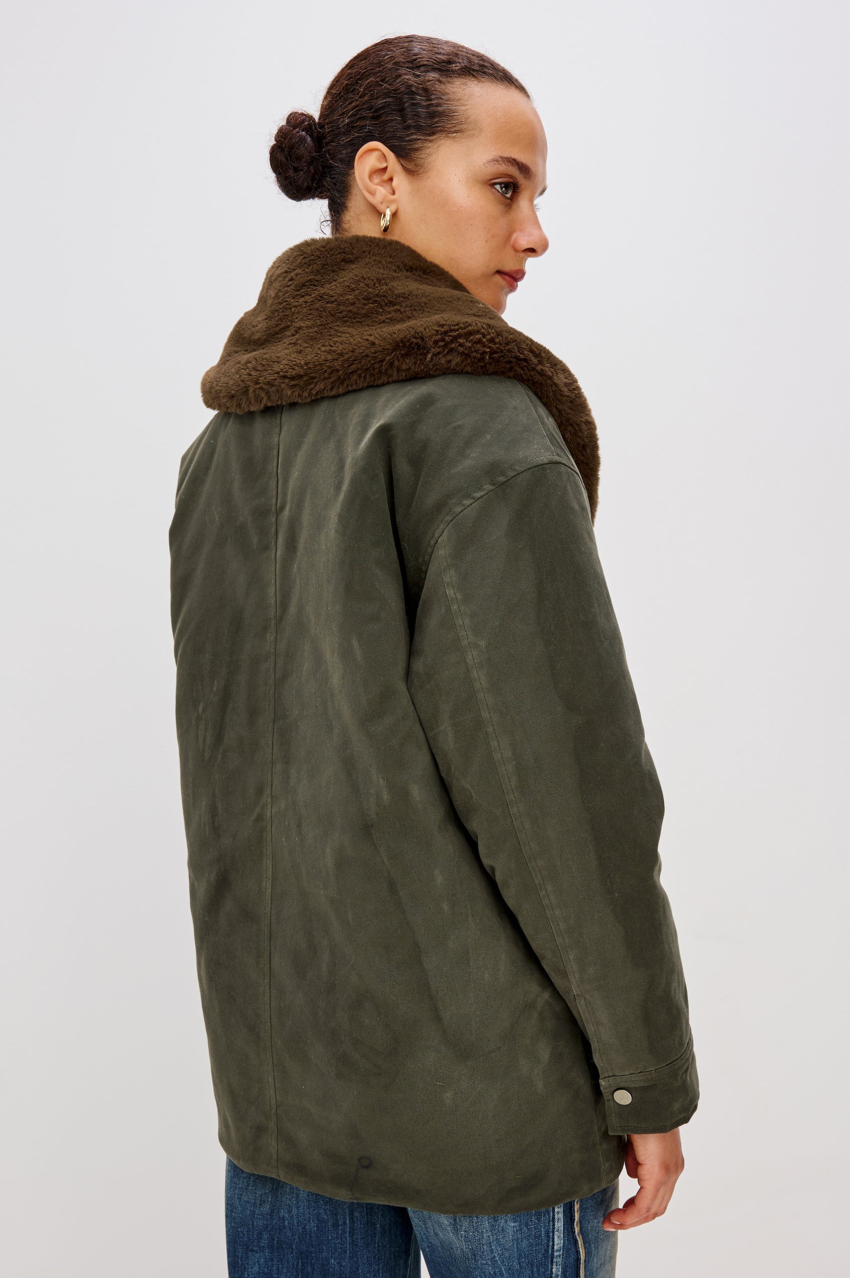 Tessuto Jacket in Waxed Cotton Canvas With Removable Vegan Fur Collar, Front Zip With Snap Closures, Long Sleeves, Quilted Lining, Single Chest Patch Pocket, and Side Pockets in Umber Colorway - Upper Body Back View Featured on Model