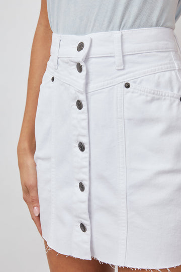Canyon Denim Mini Skirt with a Full Button Front, Belt Loops, Light Fraying along the Hem, Two Front Pockets and Two Back Patch Pockets in Salt White Colorway - Front View Featured on Model