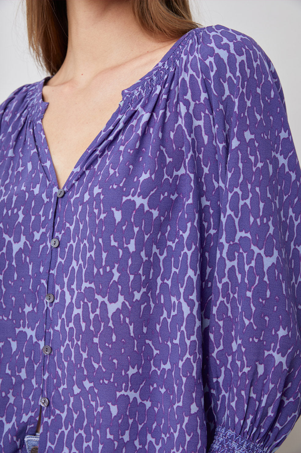 Mariah Top with Three-Quarter Sleeves, Shirred Cuffs, V-Neckline, and Buttons Down the Front in Static Leopard Print Colorway, a purple print - Front View Featured on Model  
