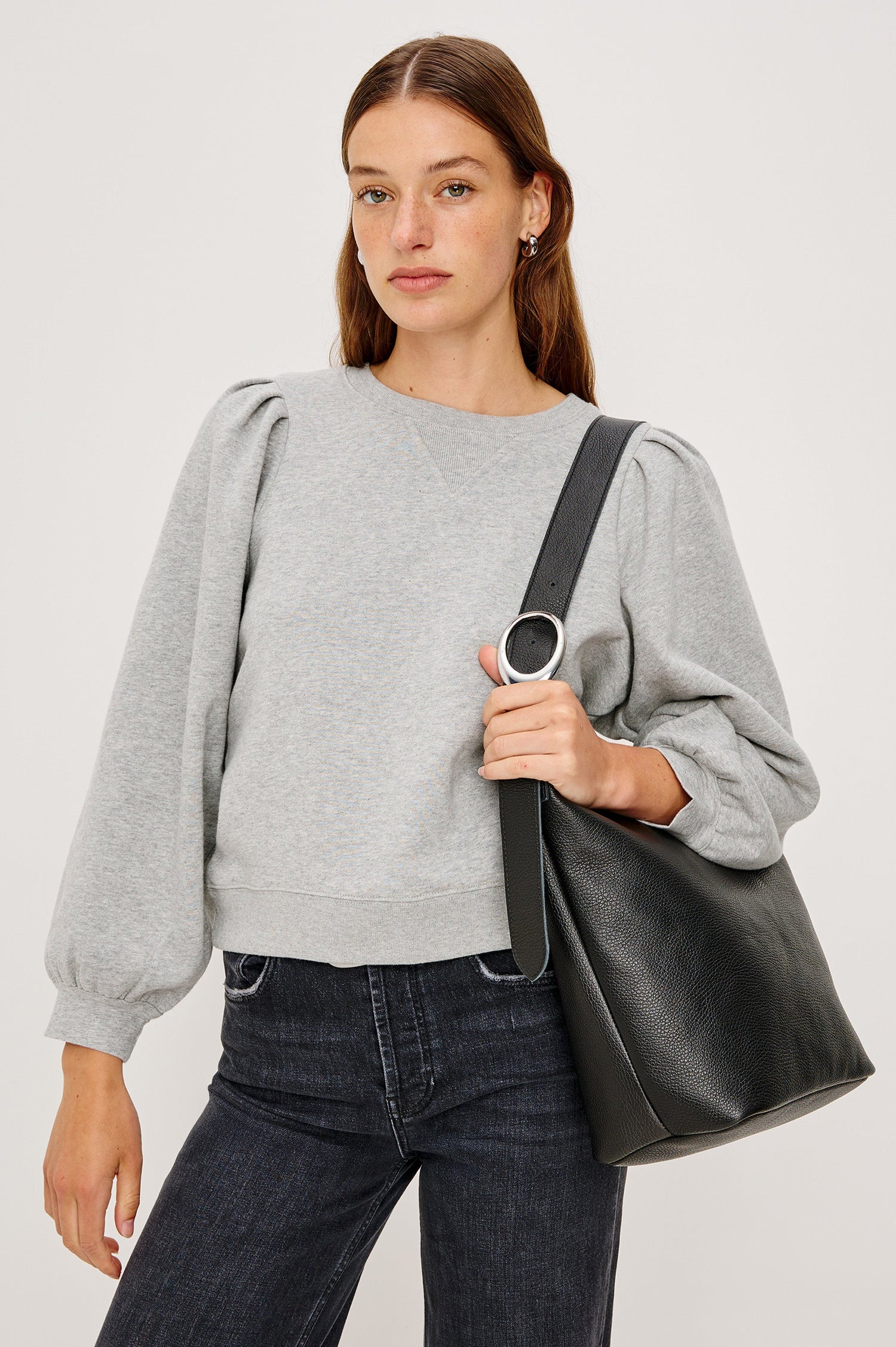 Tiffany Long-Sleeve Sweatshirt with a Crew Neck and Deep Pleated Sleeves in Heather Grey Colorway - Front View Featured on Model with Purse over shoulder