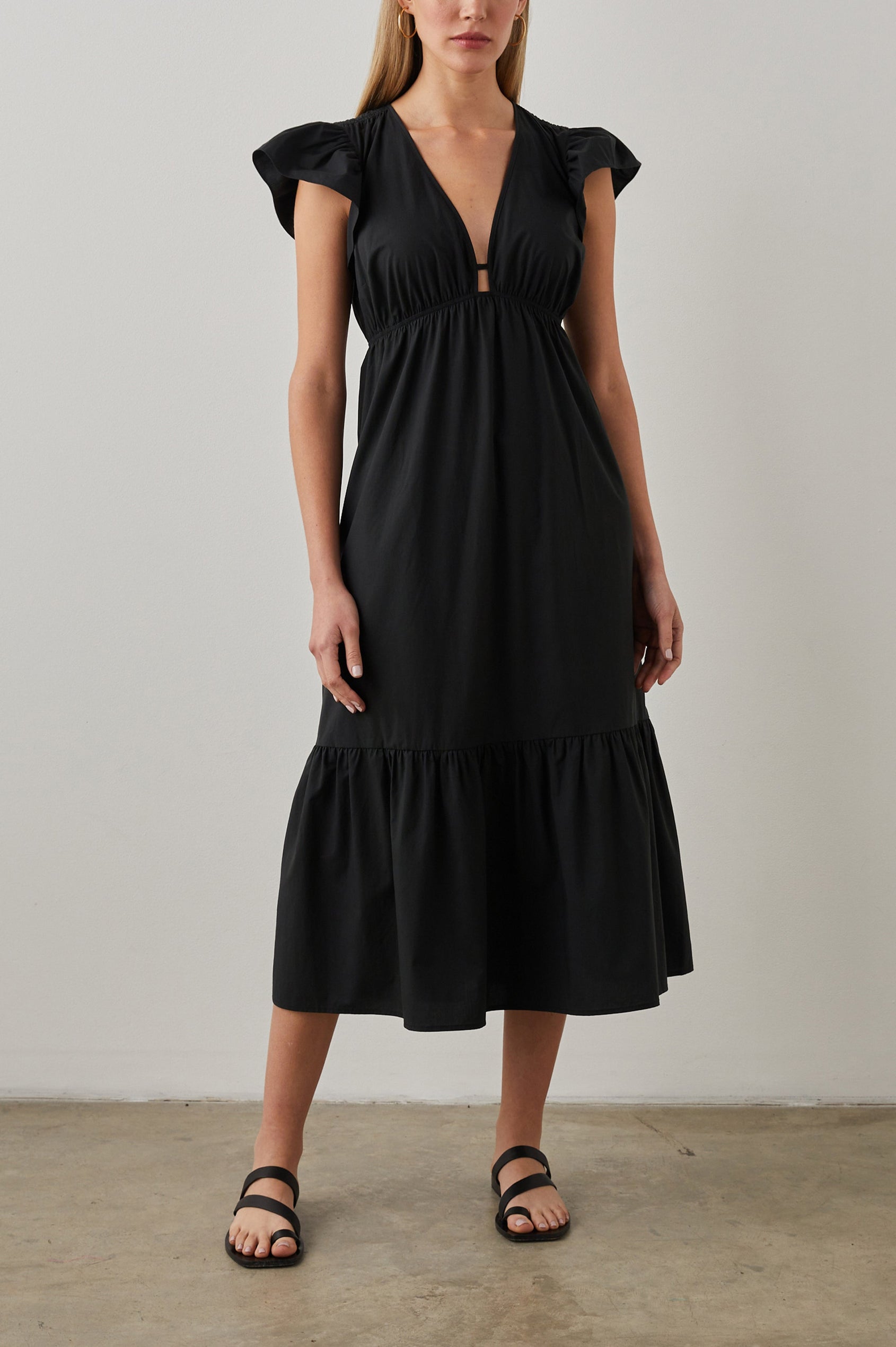 Tina Short Sleeve Midi Dress with Flutter Sleeves, a Deep V Neck with a Cutout and a Tiered Skirt in Black Colorway - Front Full Body View Featured on Model 