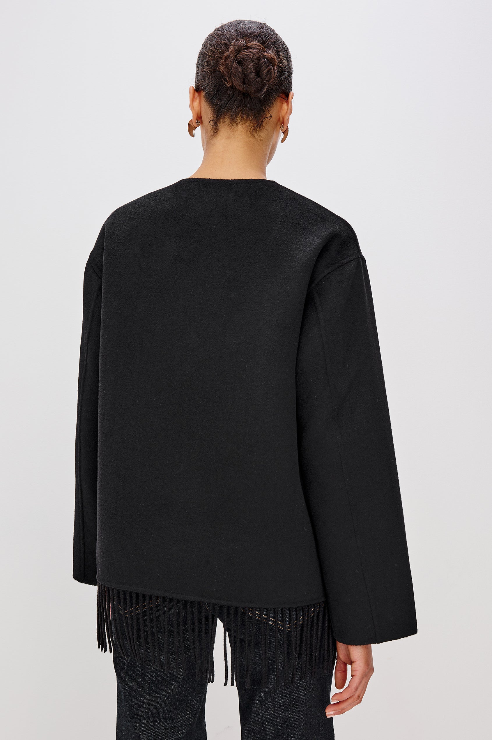 Tomoko Jacket in Heavyweight Wool Blend With Front Buttons, Patch Pockets, Relaxed Fit, Long Sleeves, and Fringe Hem in Black Colorway - Upper Body Back View Featured on Model