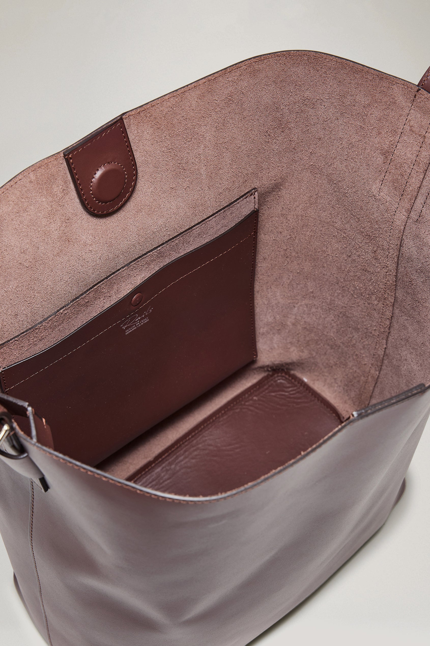 Torino Bucket Bag in Italian Leather With Adjustable Strap and Polished Silver Oval Buckle, Microsuede Lining, Interior Magnetic Closure, Snap Button-Slip Pocket, and Subtle Branded Detailing in Cowgirl Haircalf Colorway Colorway - Top Interior View Featured