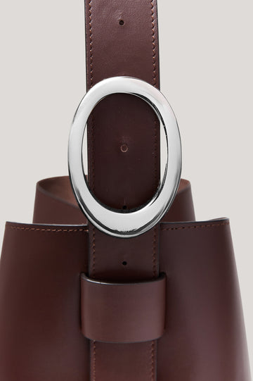 Torino Bucket Bag in Italian Leather With Adjustable Strap and Polished Silver Oval Buckle, Microsuede Lining, Interior Magnetic Closure, Snap Button-Slip Pocket, and Subtle Branded Detailing in Cowgirl Haircalf Colorway Colorway - Side Close Up View Featured