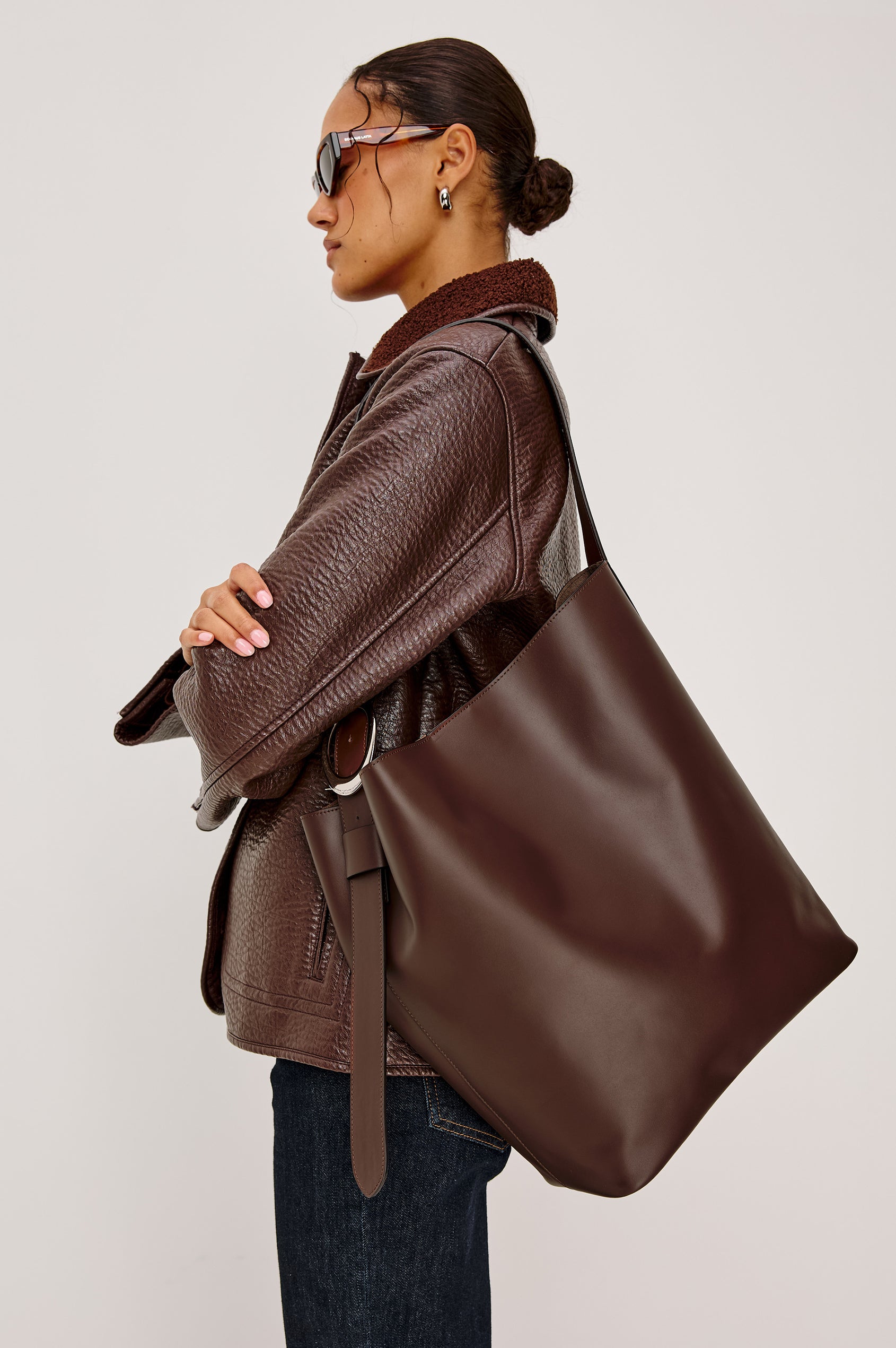 Torino Bucket Bag in Italian Leather With Adjustable Strap and Polished Silver Oval Buckle, Microsuede Lining, Interior Magnetic Closure, Snap Button-Slip Pocket, and Subtle Branded Detailing in Cowgirl Haircalf Colorway Colorway - Side View Featured