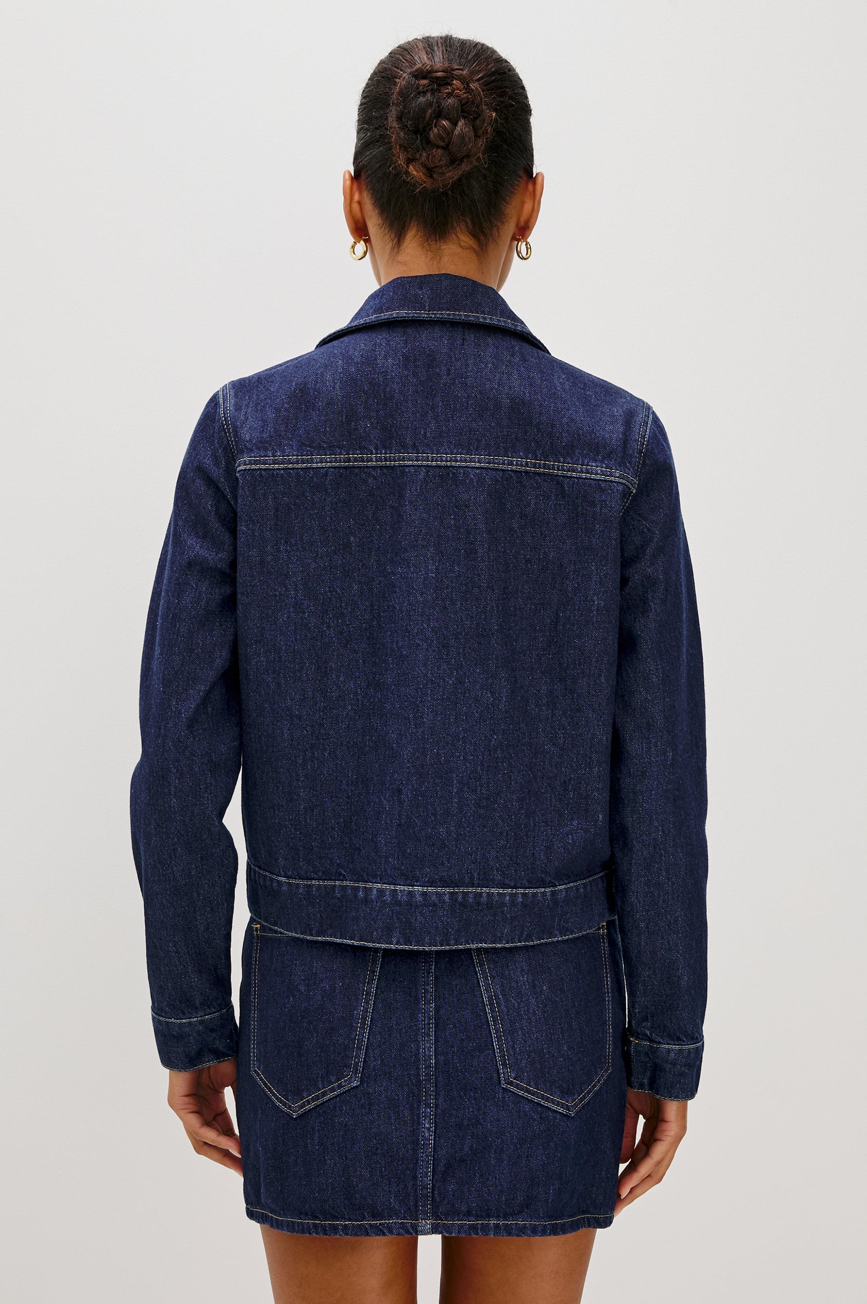 The Trabuco is a collared two-way zip front jacket with two chest pockets and a western style yoke in Deep Indigo colorway - a rinse denim wash. Back view featured on model.