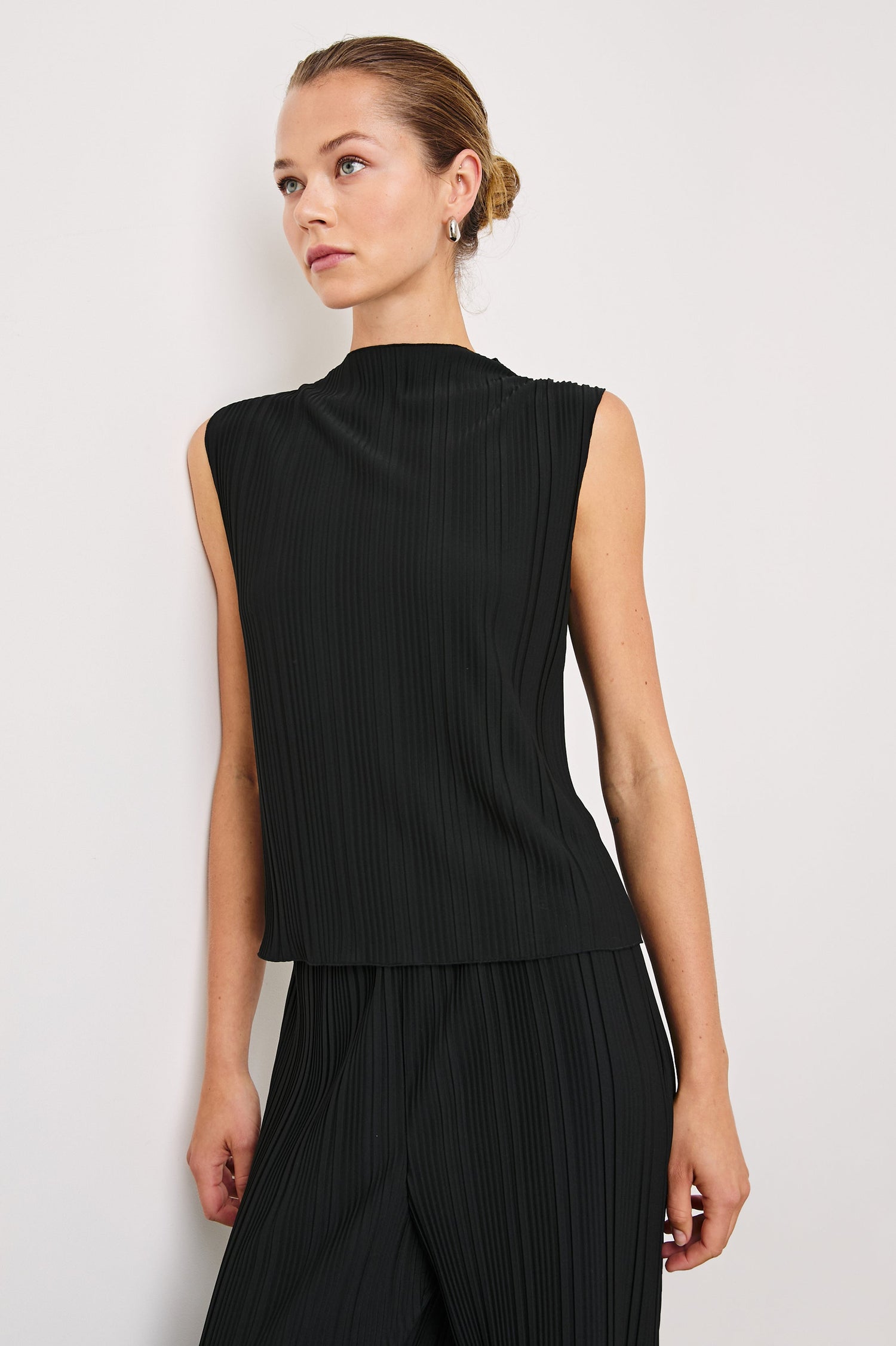 Trea Sleeveless Top with a Mock Neck and Pleated Texture in Jet Colorway - Front View Featured on Model