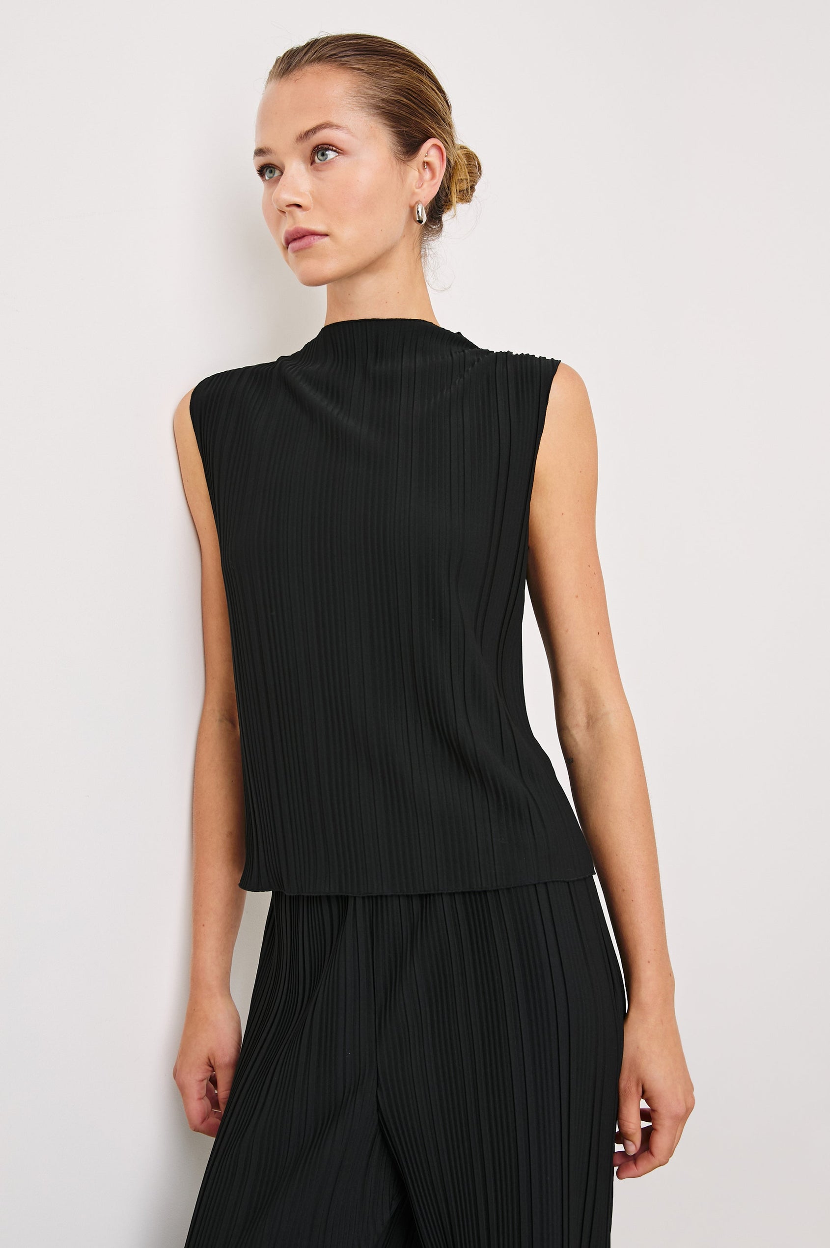 Trea Sleeveless Top with a Mock Neck and Pleated Texture in Jet Colorway - Front View Featured on Model