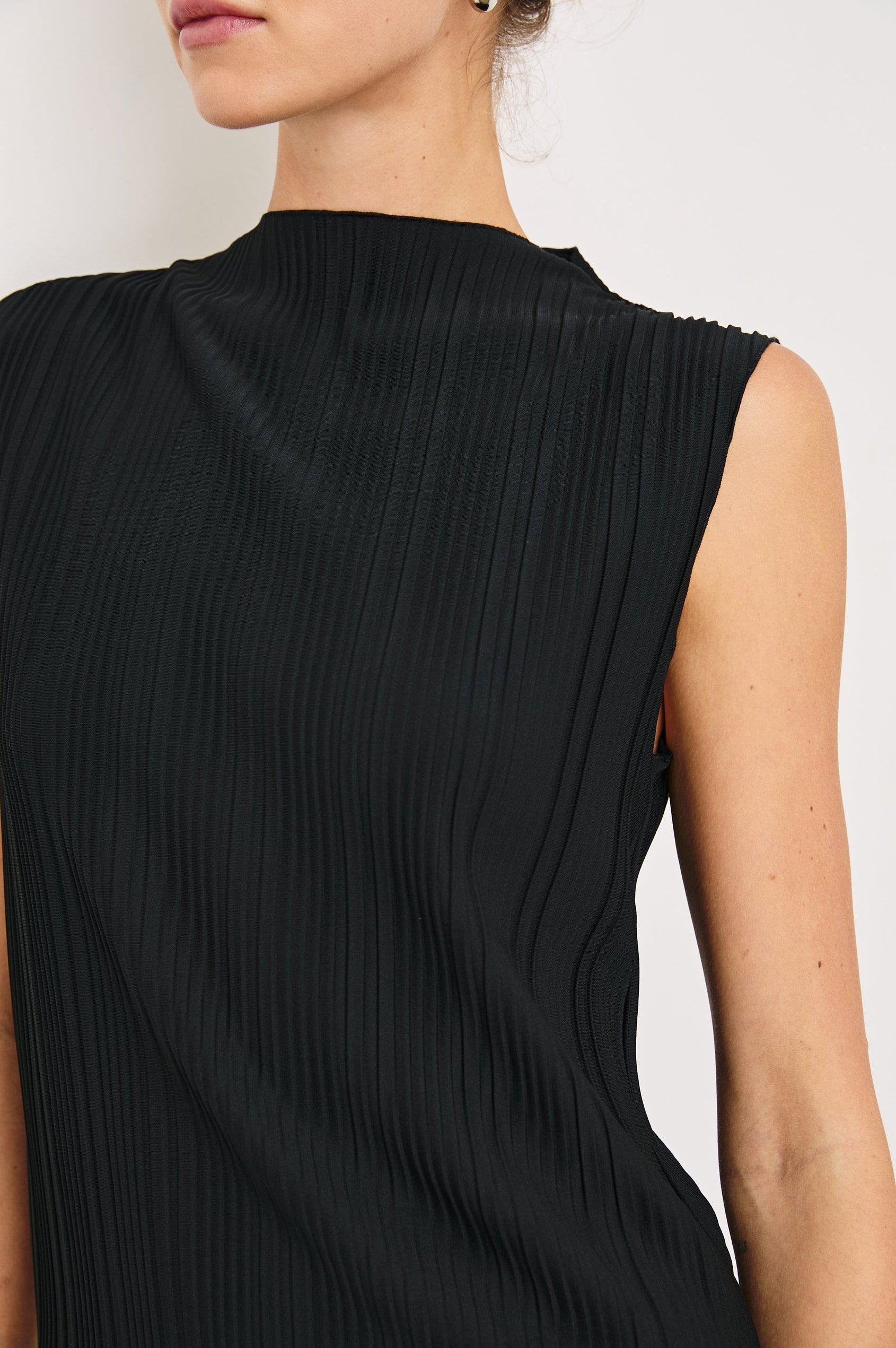 Trea Sleeveless Top with a Mock Neck and Pleated Texture in Jet Colorway - Front View Featured on Model