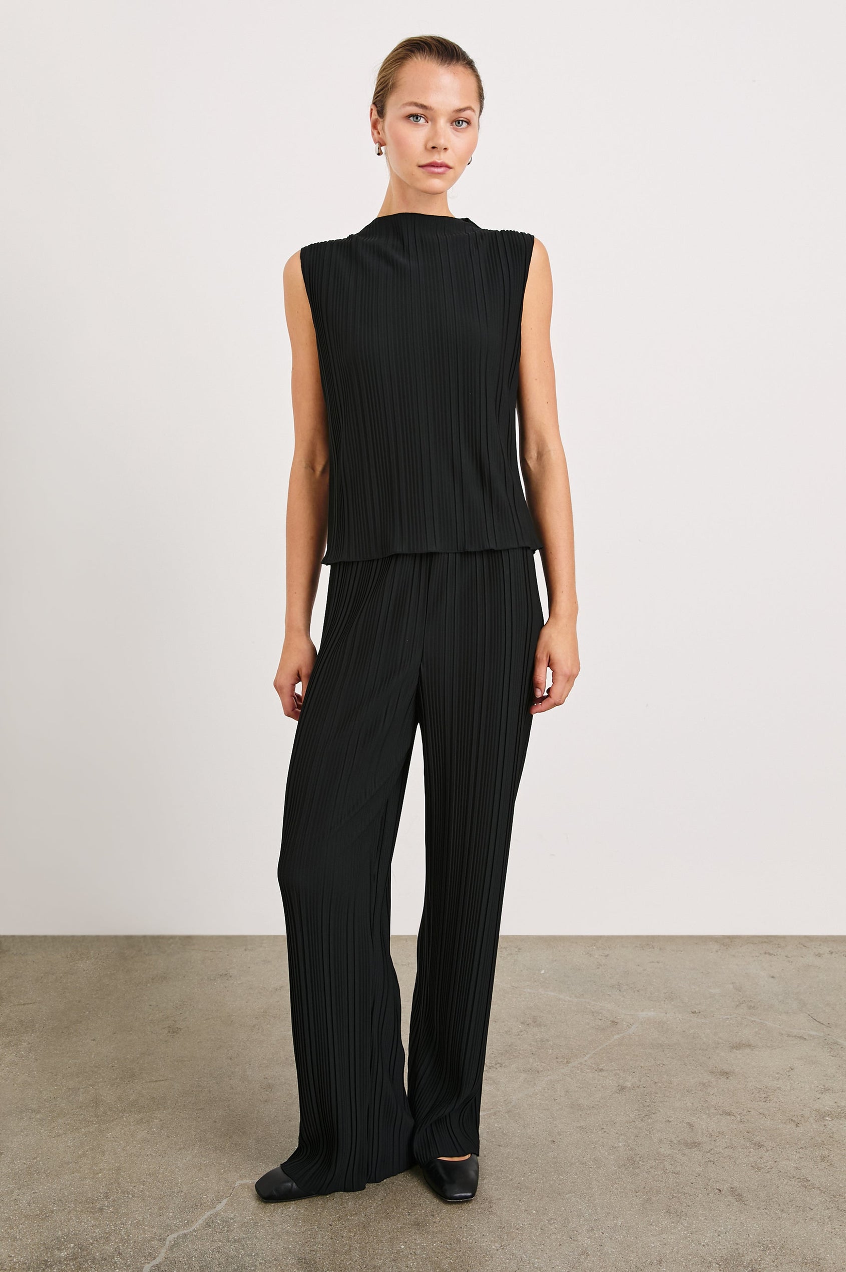 Trea Sleeveless Top with a Mock Neck and Pleated Texture in Jet Colorway - Front Full Body View Featured on Model
