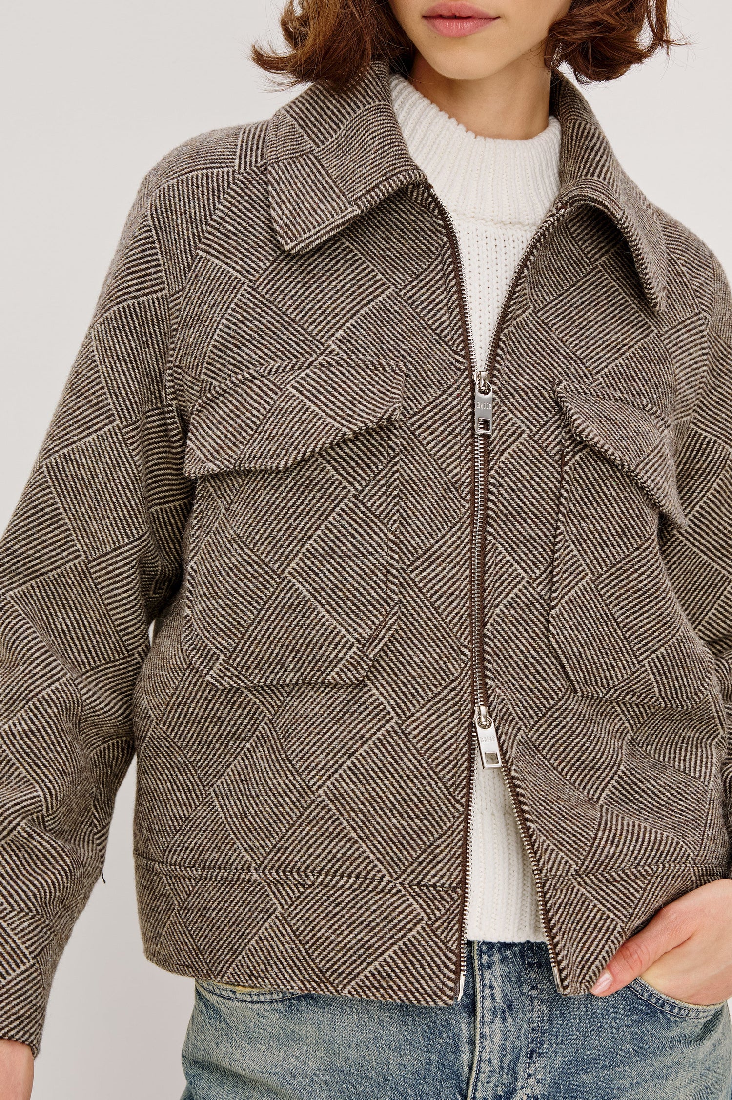 Truckee, a heavyweight wool-blend aviation-style jacket with a textured basketweave pattern. The jacket is fully lined and features oversized flap chest pockets and a two-way front zipper. Close Up View featured on model, Zipped Up