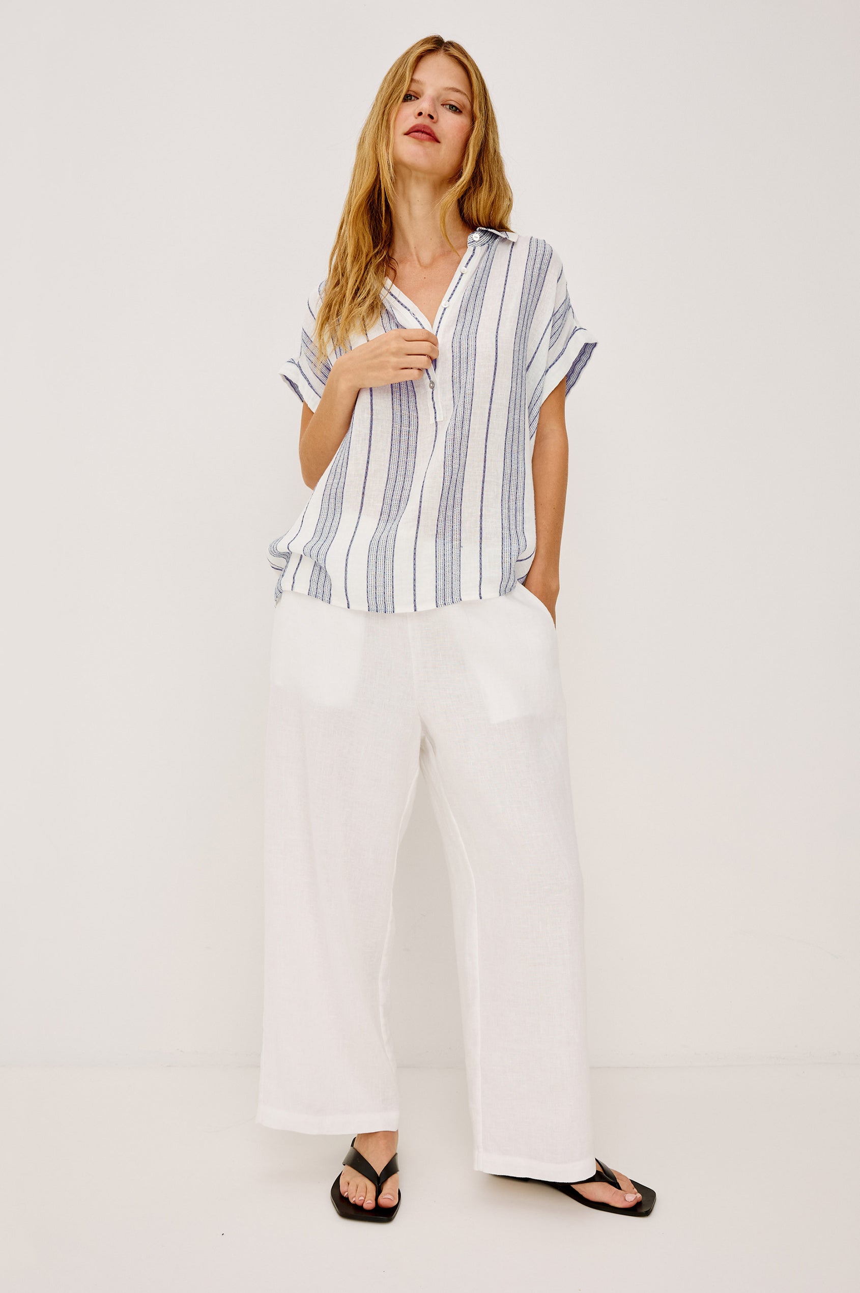 Tuscany Shirt in Linen Blend With Collar, Front Half Placket, Capped Cuff Sleeves, and Slightly-Boxy Fit Fit in Washed Blue Colorway - Full Body Front View Featured on Model