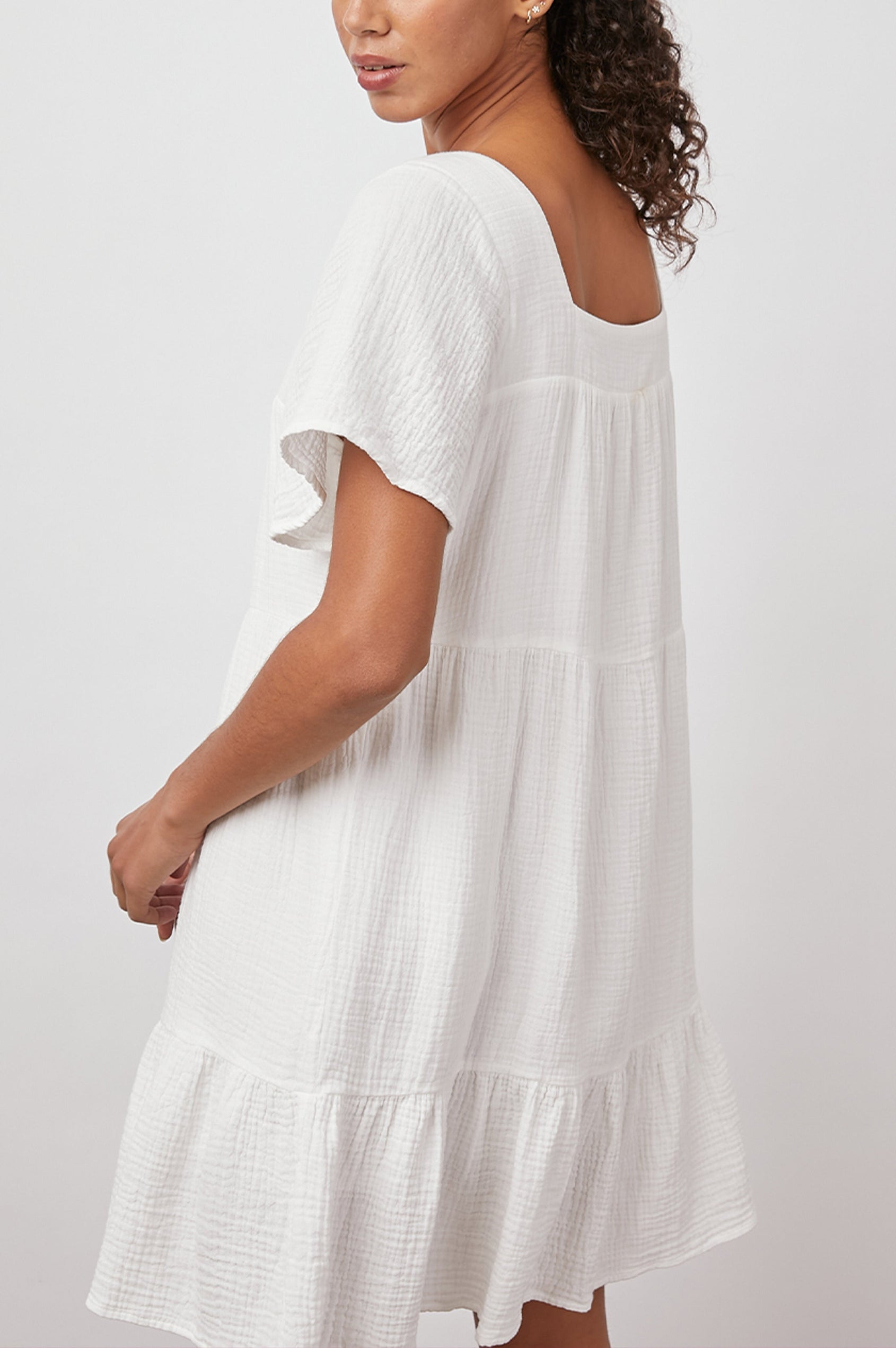 Valentina Short-Sleeve Tiered Mini Dress with a Square Neckline in White Colorway - Side View Featured on Model 
