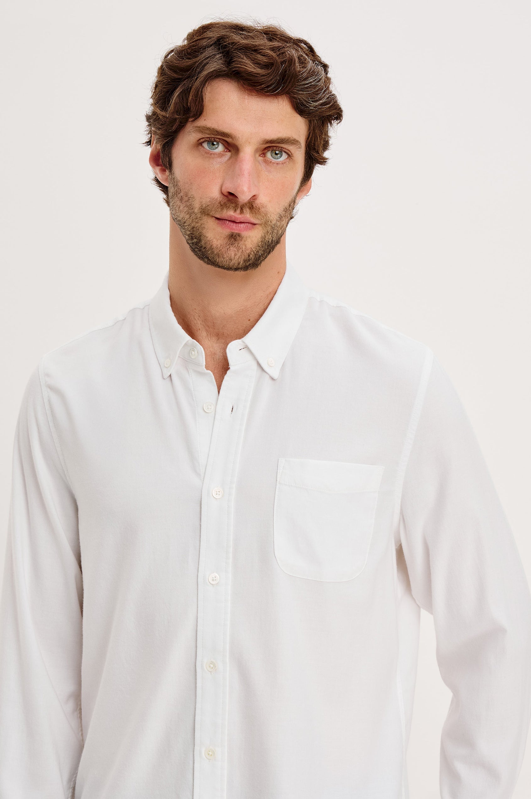 Vance button front collared shirt with long sleeves, collard stand buttons and a single chest pocket in White colorway. Front close up view featured on model.