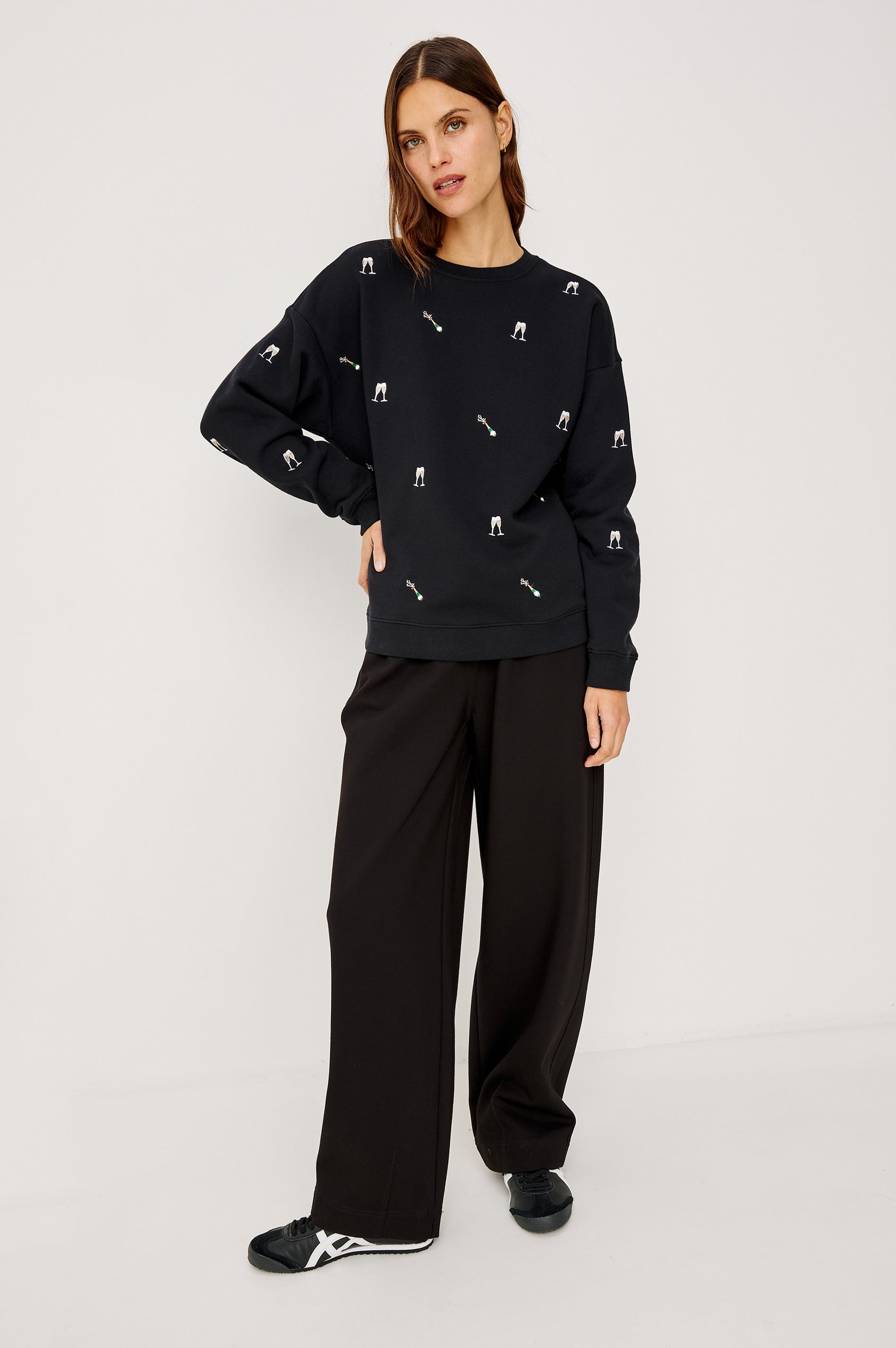 Ramona Crewneck Sweatshirt in Cotton Fleece With Embroidered Champagne Glasses, Dropped Shoulders, Long Sleeves, and Ribbed Trim in Black Champagne Embroidery Colorway - Full Body Front View Featured on Model