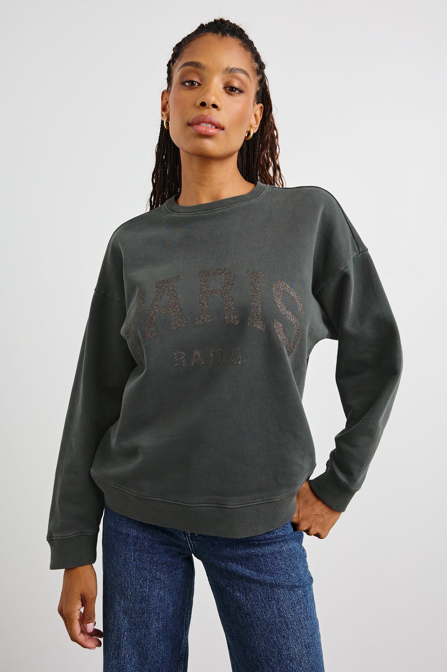 The Varsity Sweatshirt with a Crew Neck and Glitter Text states, Paris Rails in Paris Glitter Colorway, on dark grey - Front View Featured on Model 
