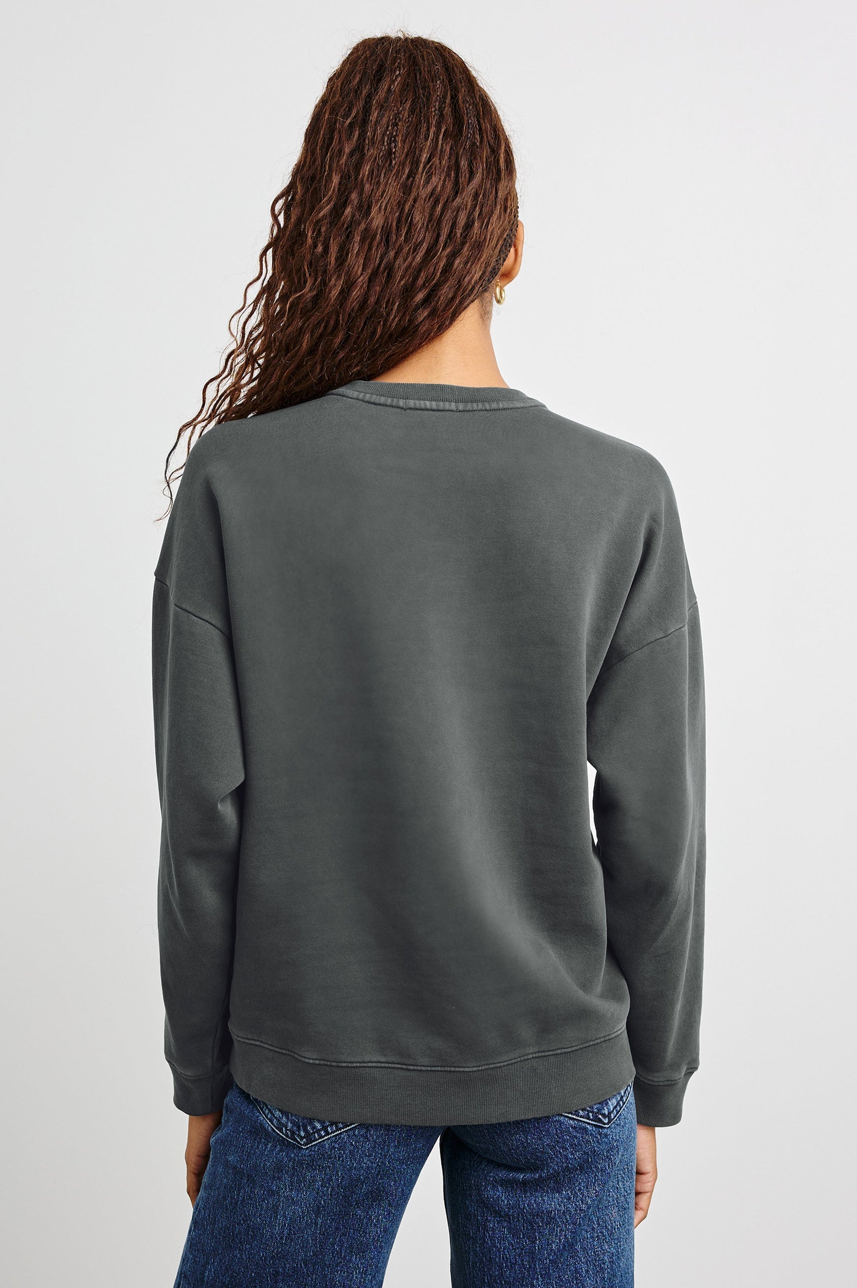 The Varsity Sweatshirt with a Crew Neck and Glitter Text states, Paris Rails in Paris Glitter Colorway, on dark grey - Back View Featured on Model 