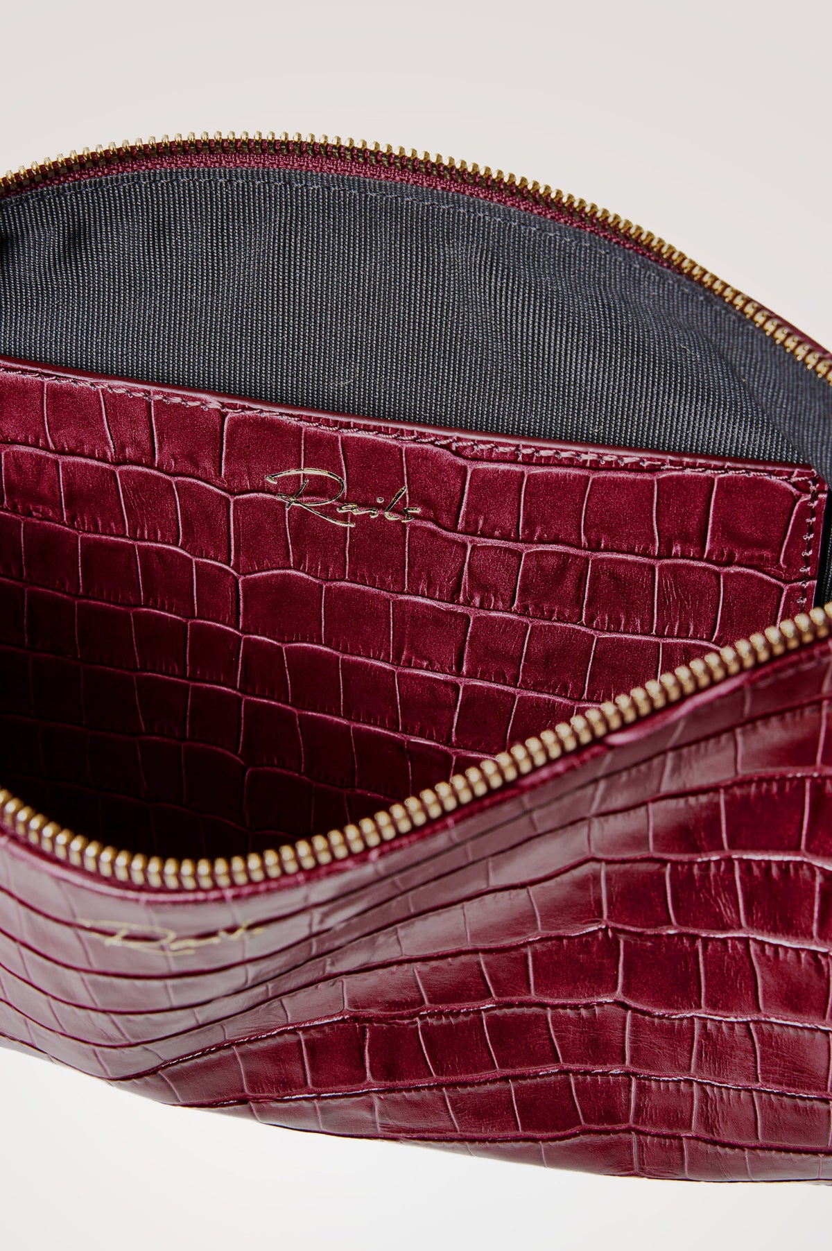 Verona Clutch Bag in Croc-Embossed Leather With Attached Wristlet Strap, Top Zip Closure, and Interior Slip Pocket in Burgundy Croc Embossed Colorway - Front Product View Featured