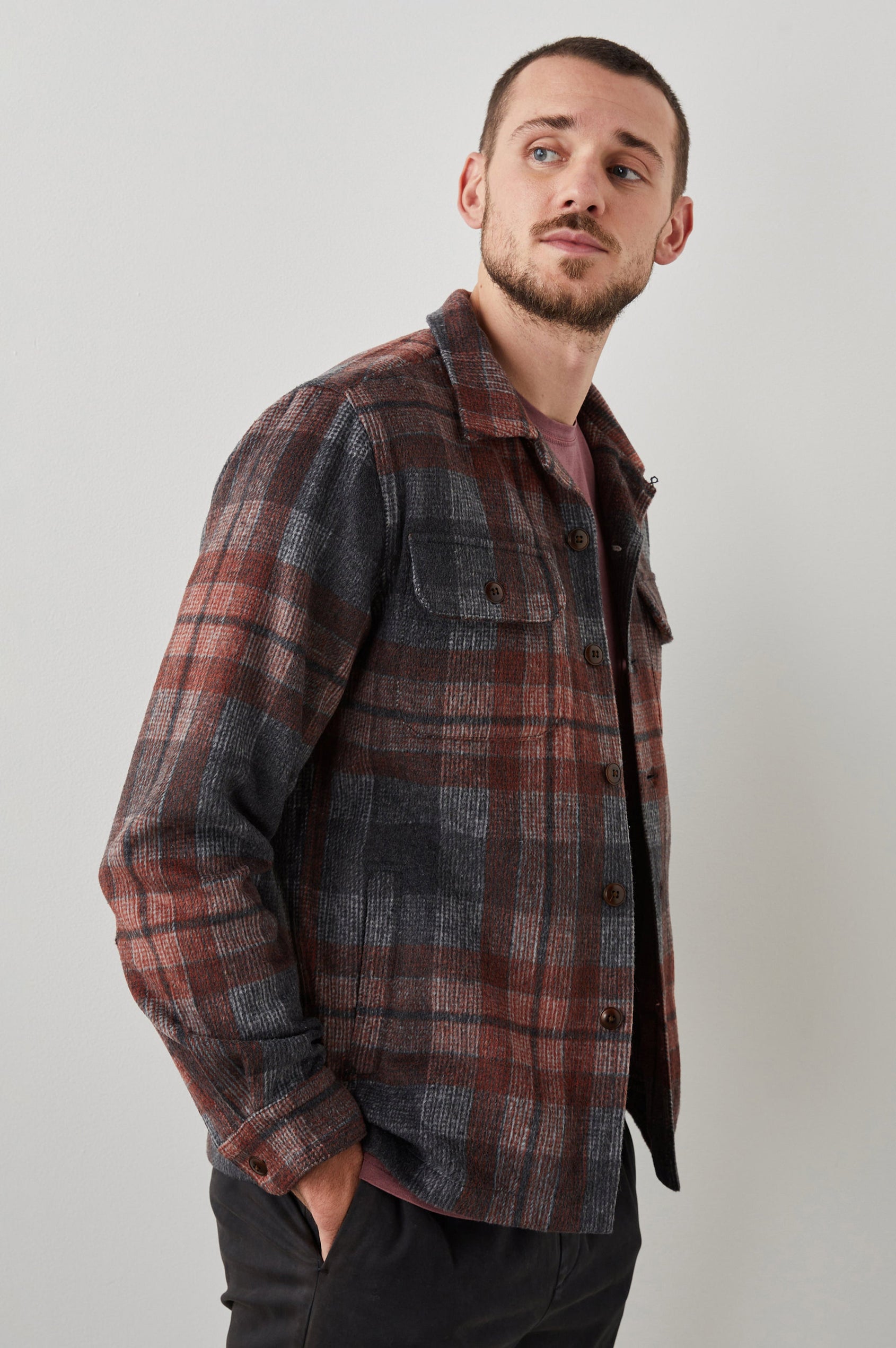 Viggo Long-Sleeve Shirt Jacket with Button Closure and Two Button Chest Flap Pockets in Crimson Shadow Plaid Colorway - Side Unbuttoned View Featured on Model