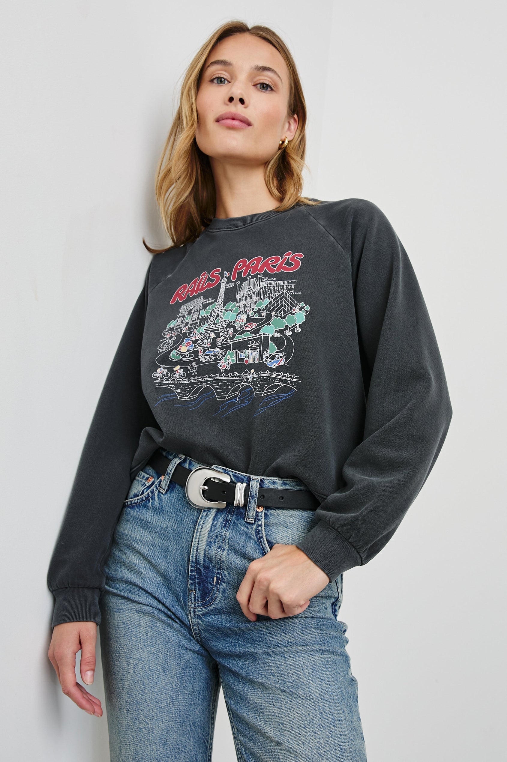 Vintage Raglan Long-Sleeve Sweatshirt with a Crew Neck, an image of landmarks in Paris and the Text, Rails Paris in Rails Paris Map Colorway, Mostly White and Green on Black - Front View Featured on Model
