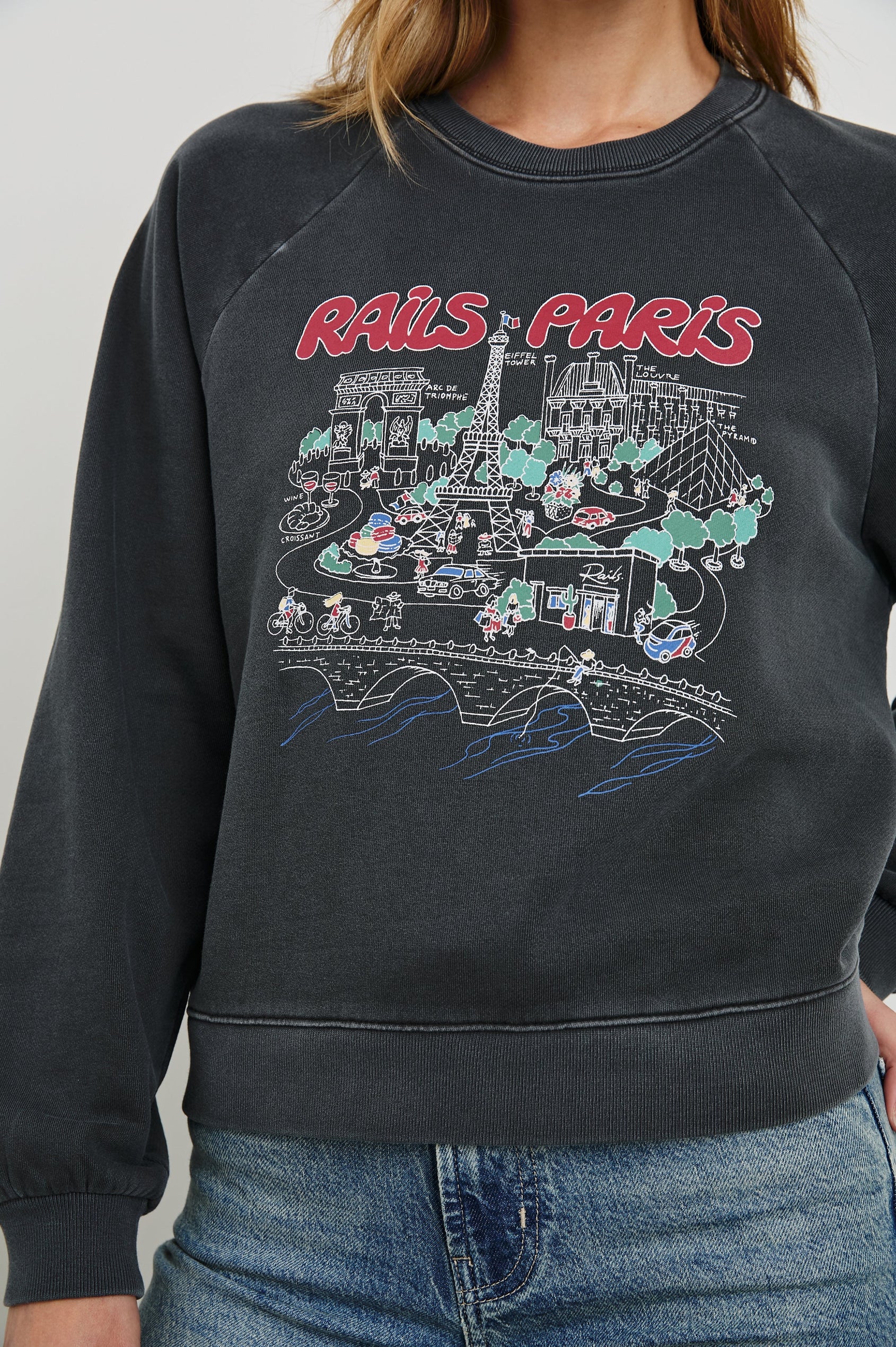 Vintage Raglan Long-Sleeve Sweatshirt with a Crew Neck, an image of landmarks in Paris and the Text, Rails Paris in Rails Paris Map Colorway, Mostly White and Green on Black - Front View Featured on Model