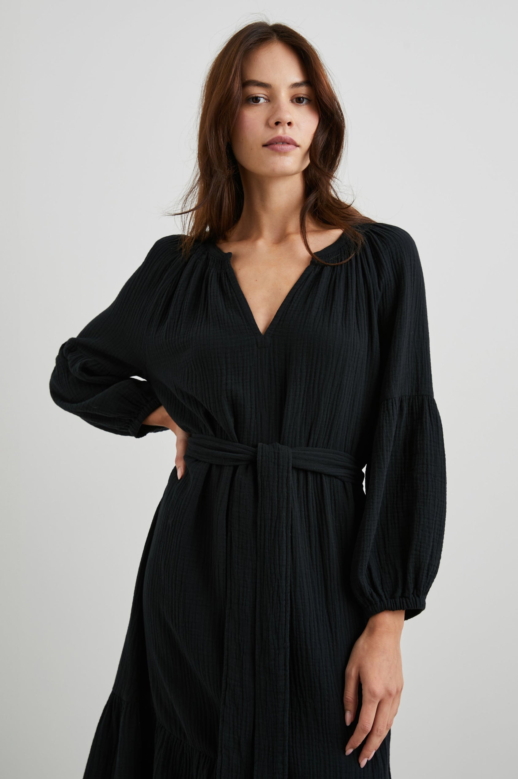 Vittoria Midi Dress with Three-Quarter Sleeves, a V Neck, Light Ruching at the Collar, and a Fabric Tie Belt in Black Colorway - Front View Featured on Model