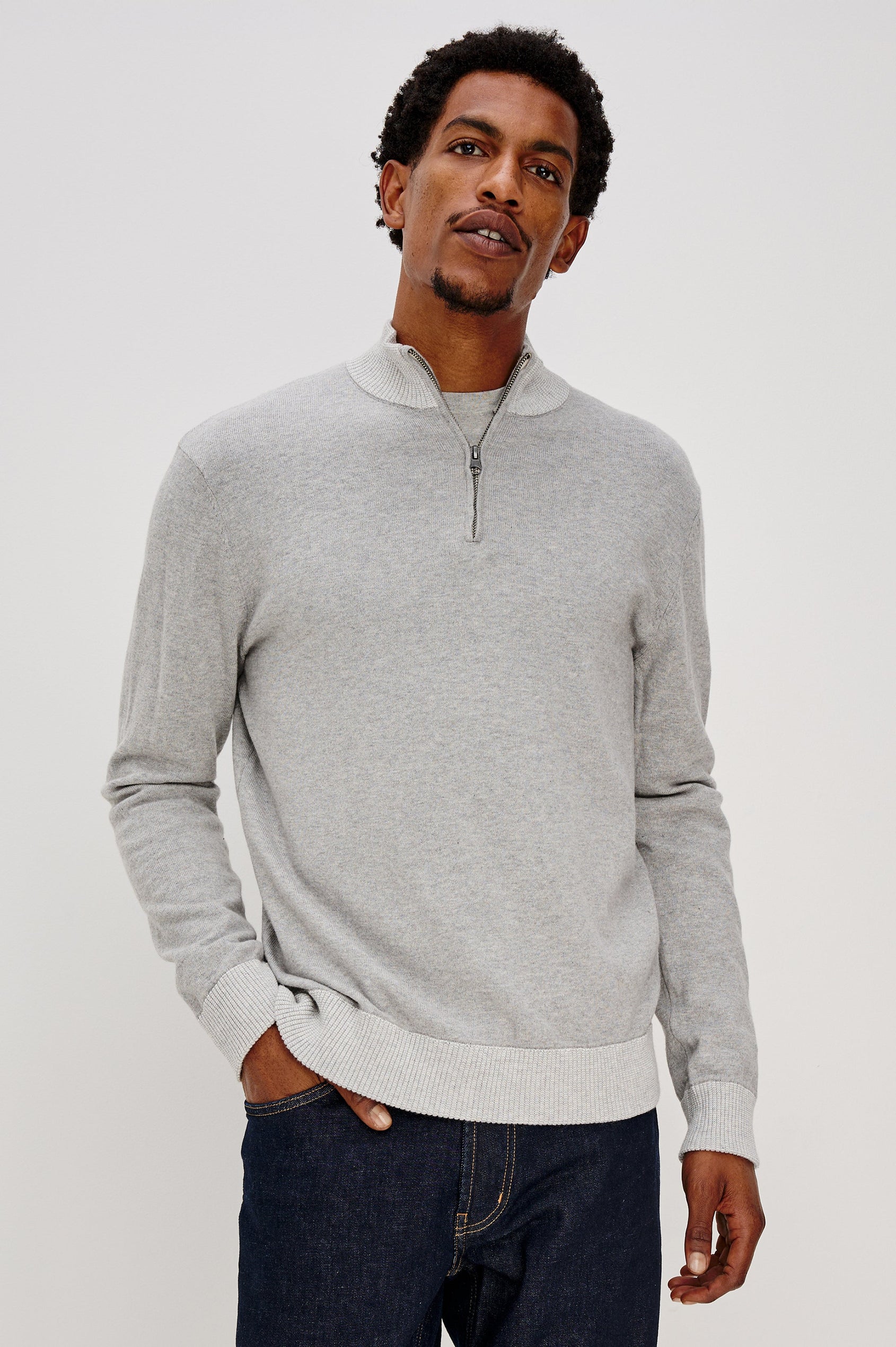 The Waylon is a quarter zip mock neck sweater with long sleeves and rib trim in Grey Heather colorway. Front view featured on model.