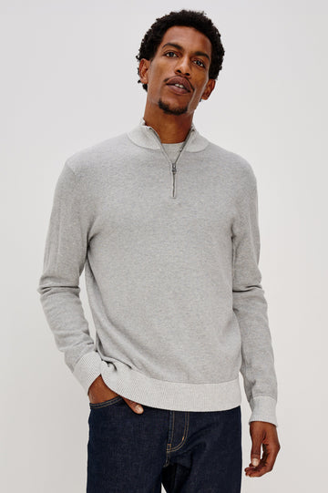 The Waylon is a quarter zip mock neck sweater with long sleeves and rib trim in Grey Heather colorway. Front view featured on model.