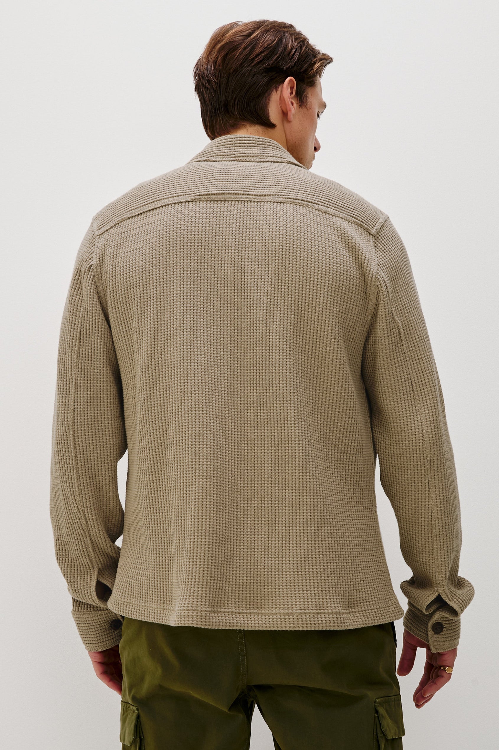 The Wells is a collared button front shirt jacket with contrast brown buttons and two chest pockets in Barley colorway. Back view featured on model.