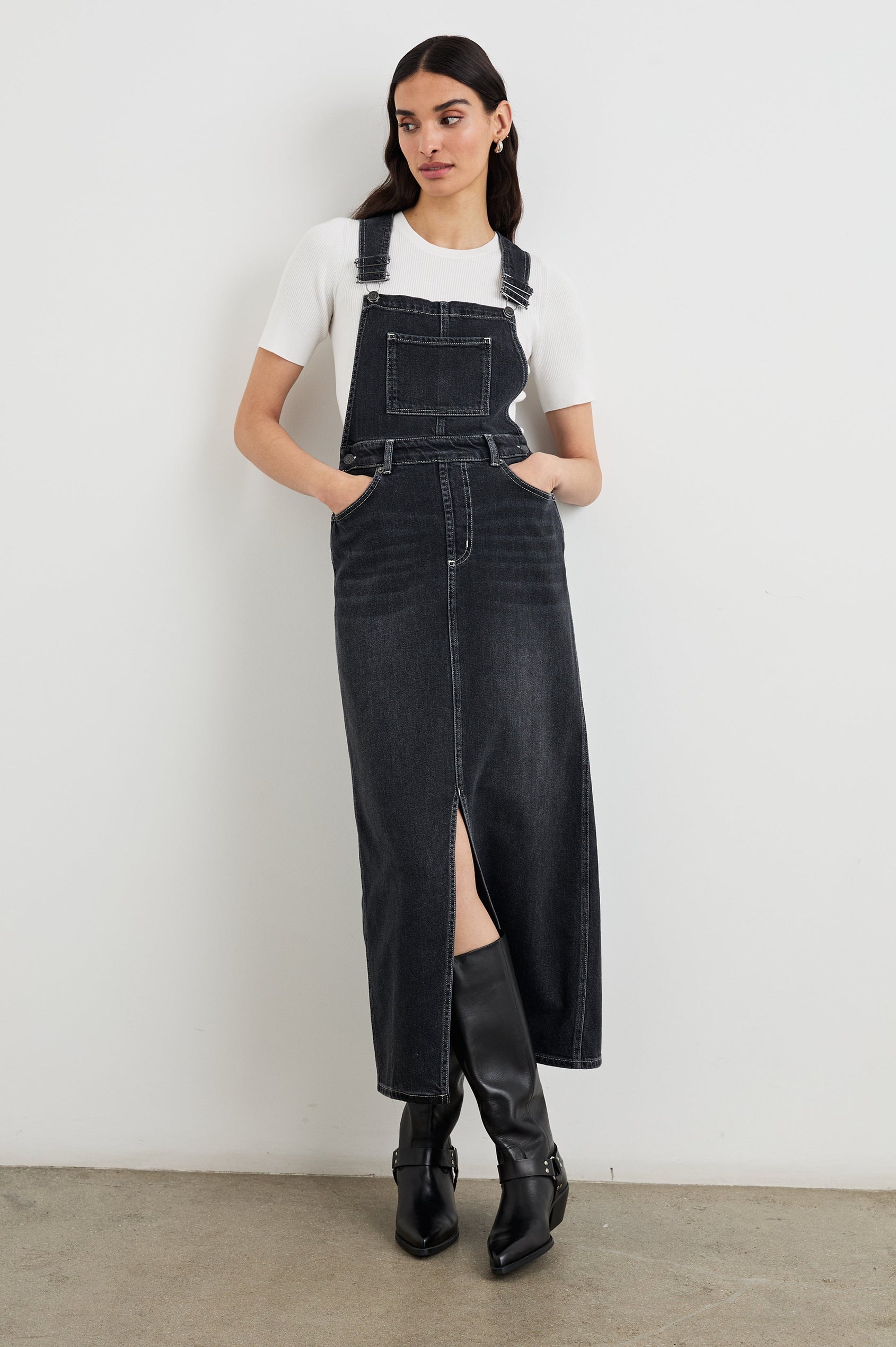 Westlake Midi Denim Dress with an Overalls-Style Bodice, Two Front Pockets, a Bib Chest Patch Pocket, Two Back Patch Pockets, Belt Loops and a Center Slit in Black Sand Colorway - Front Full Body View Featured on Model