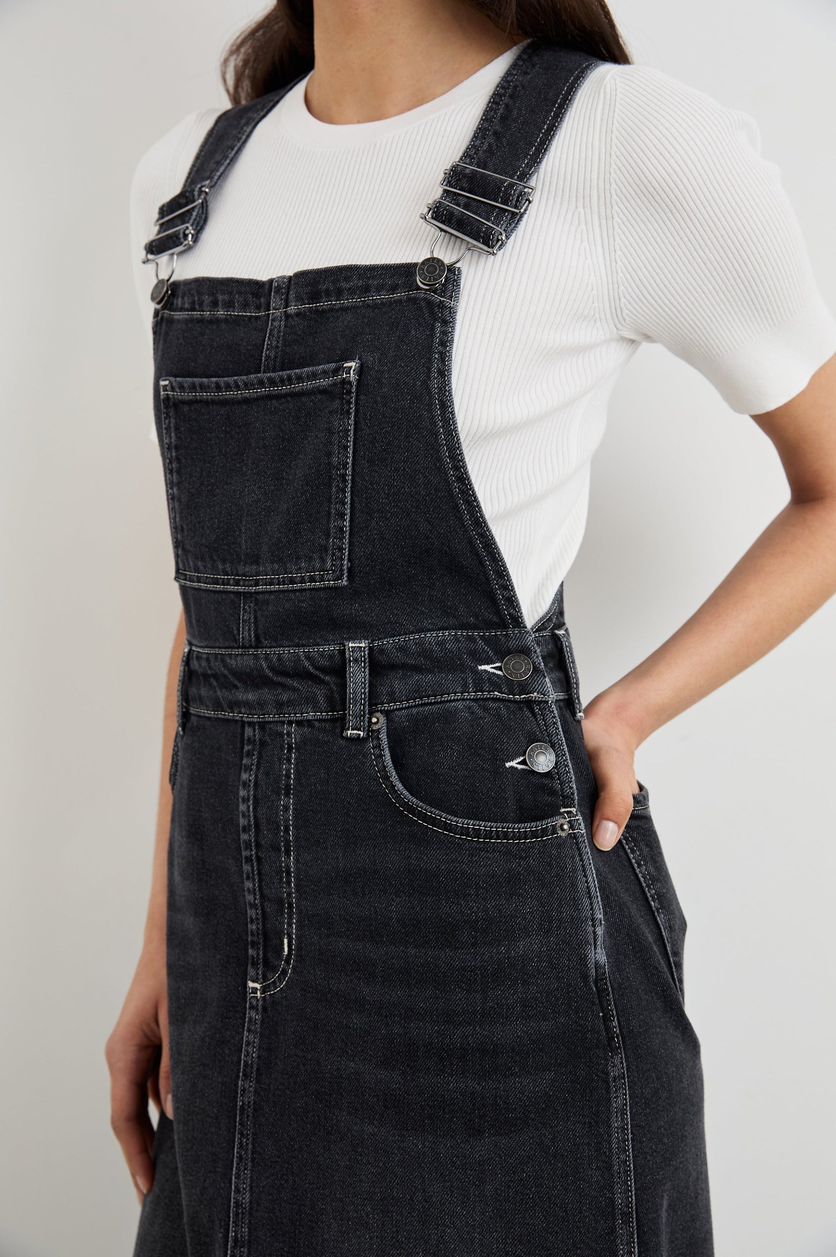 Westlake Midi Denim Dress with an Overalls-Style Bodice, Two Front Pockets, a Bib Chest Patch Pocket, Two Back Patch Pockets, Belt Loops and a Center Slit in Black Sand Colorway - Front View Featured on Model