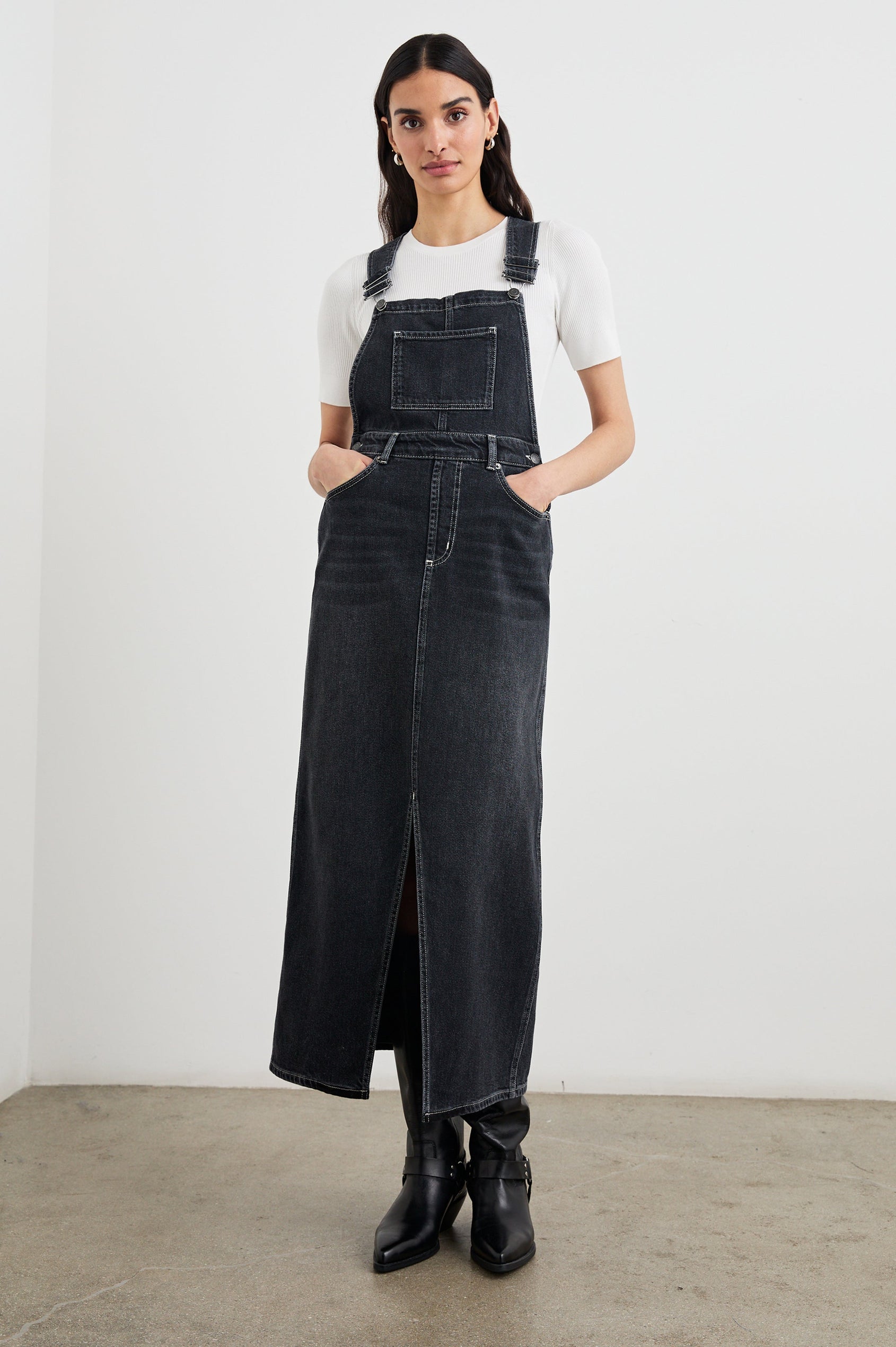Westlake Midi Denim Dress with an Overalls-Style Bodice, Two Front Pockets, a Bib Chest Patch Pocket, Two Back Patch Pockets, Belt Loops and a Center Slit in Black Sand Colorway - Front Full Body View Featured on Model