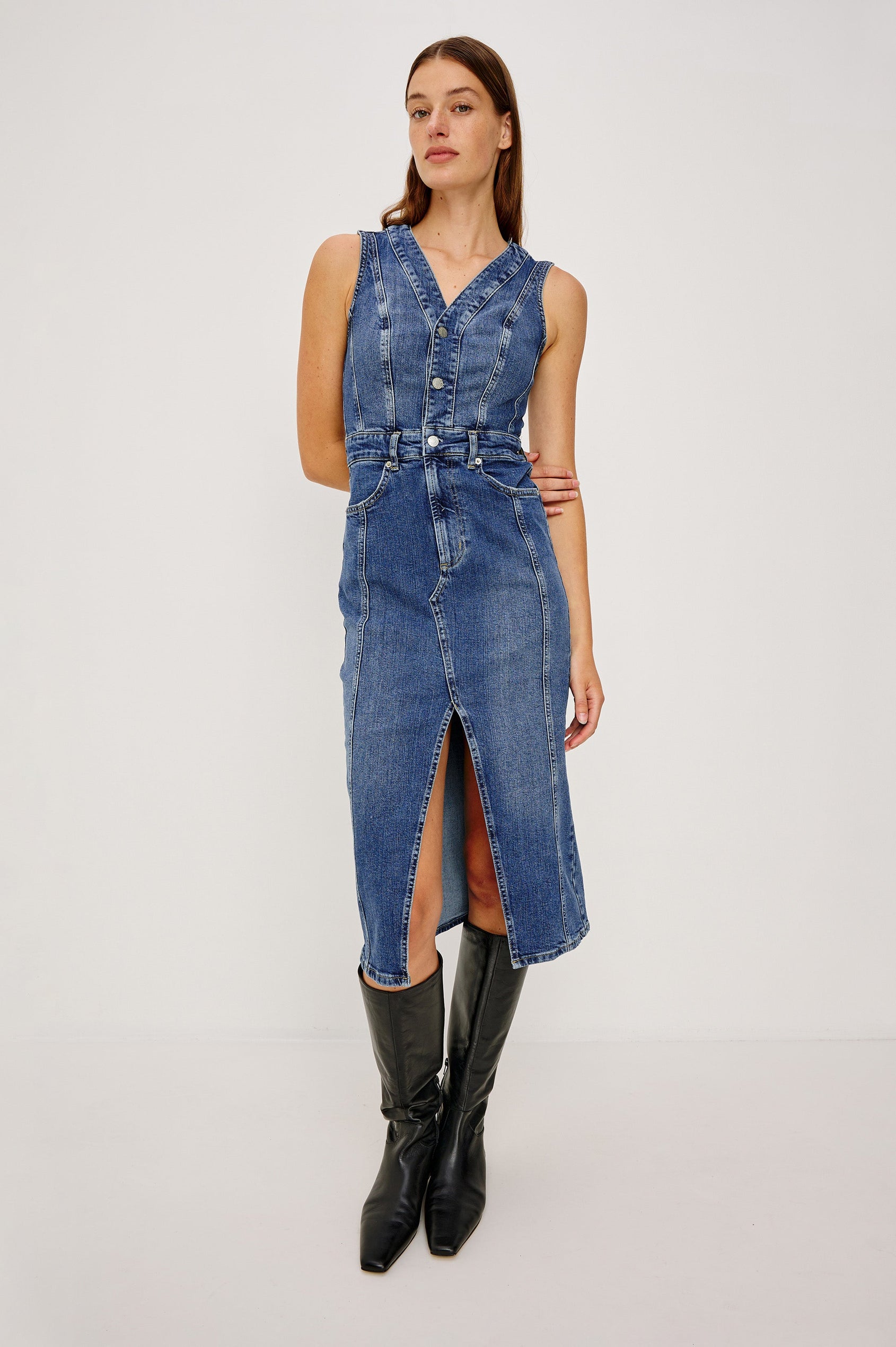 Westwood Sleeveless Denim Midi Dress with Belt Loops, a Button and Zipper Closure for the Skirt and Button Closure on the Bodice, a V neck, a Front Center Thigh Slit, Two Front Pockets  and Two Back Patch Pockets in Forget Me Not Colorway, a Blue - Front Full Body View Featured on Model
