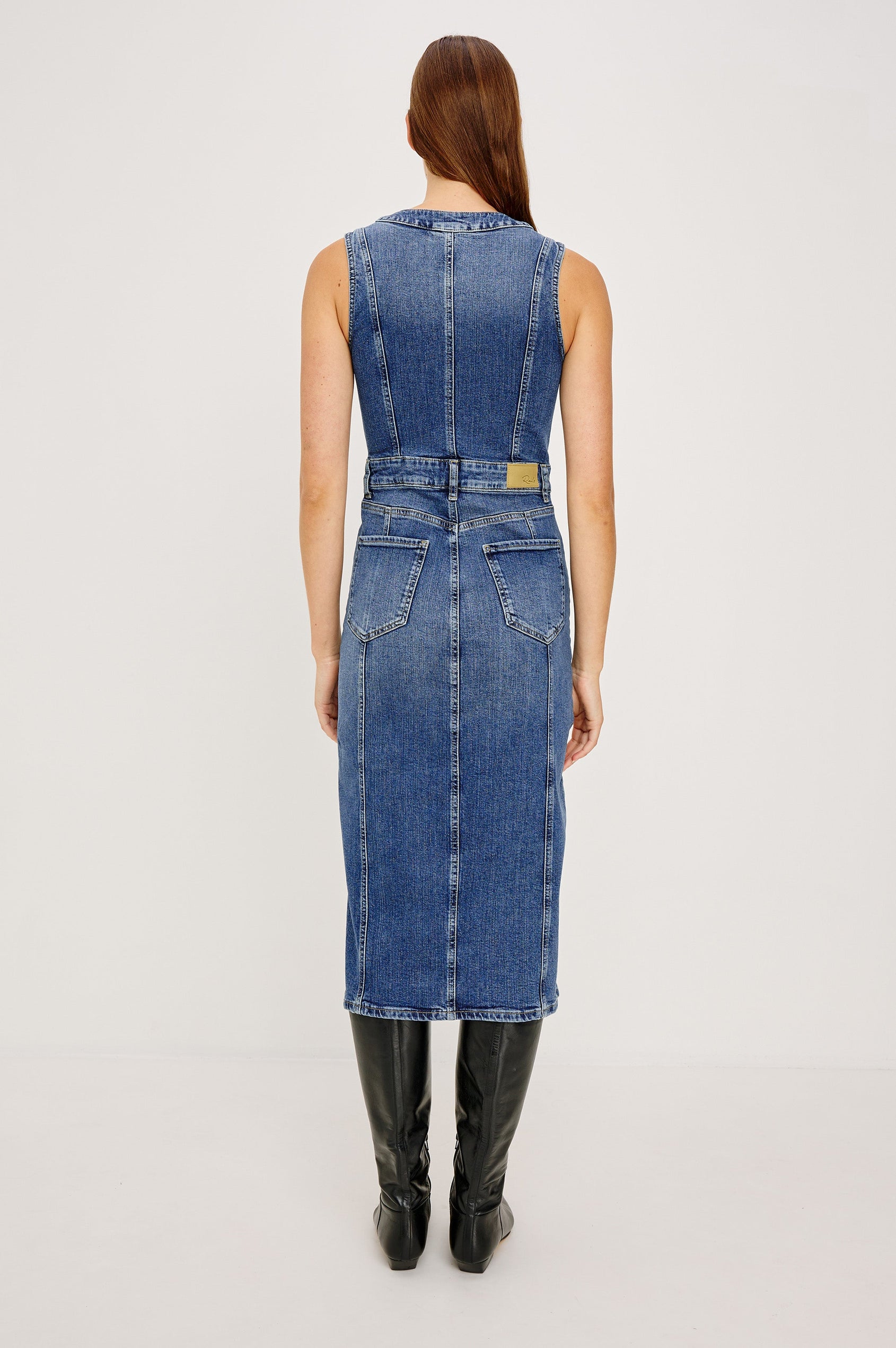 Westwood Sleeveless Denim Midi Dress with Belt Loops, a Button and Zipper Closure for the Skirt and Button Closure on the Bodice, a V neck, a Front Center Thigh Slit, Two Front Pockets  and Two Back Patch Pockets in Forget Me Not Colorway, a Blue - Back Full Body View Featured on Model