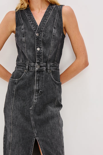 Westwood Sleeveless Denim Midi Dress with Belt Loops, a Button and Zipper Closure for the Skirt and Button Closure on the Bodice, a V neck, a Front Center Thigh Slit, Two Front Pockets  and Two Back Patch Pockets in Black Pearl Colorway, a washed black- Front Detail View Featured on Model