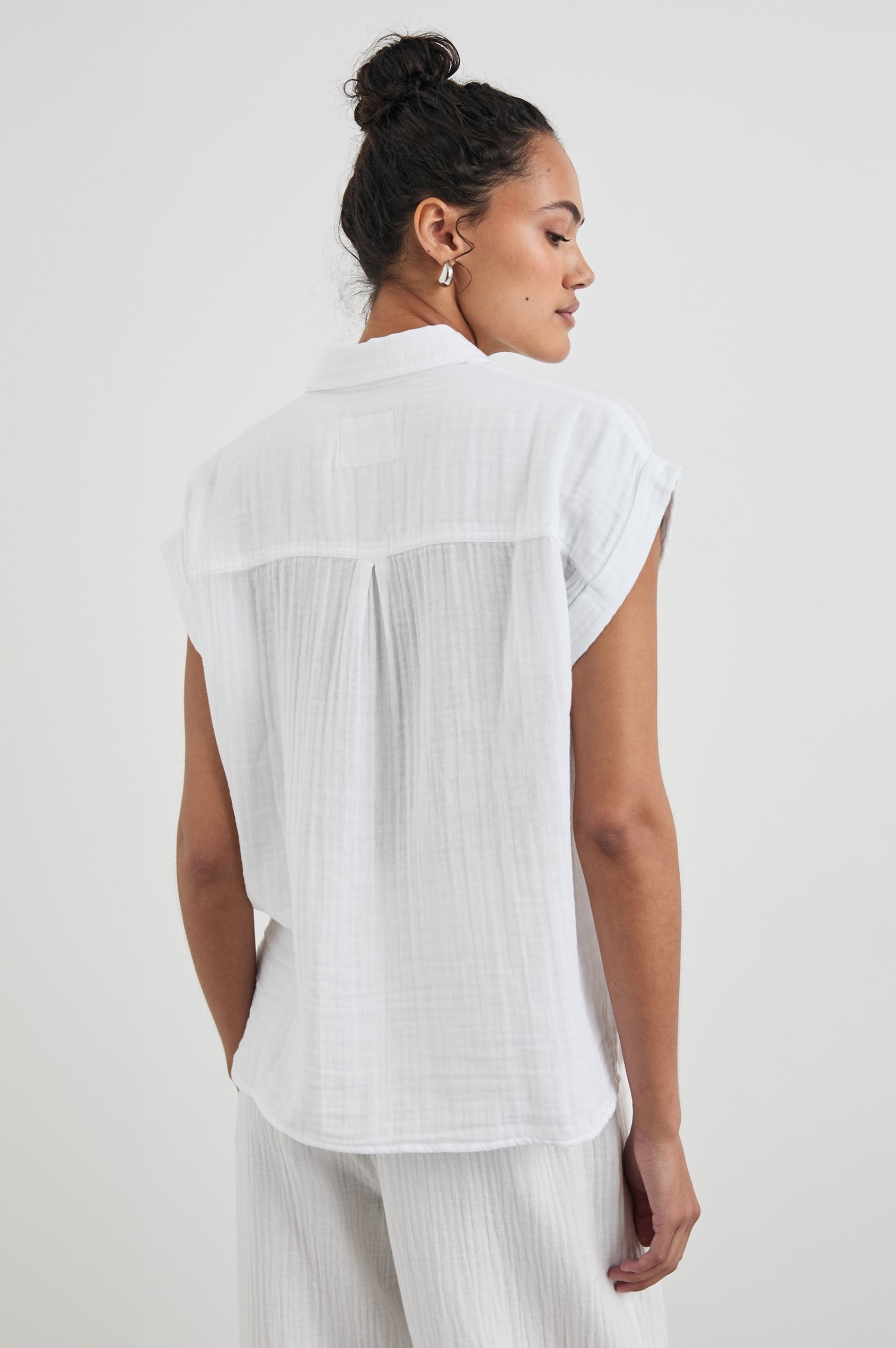 Whitney Short Rolled Sleeves Button Up with a Chest Patch Pocket and Short Side Slits in White Colorway - Back View Featured on Model