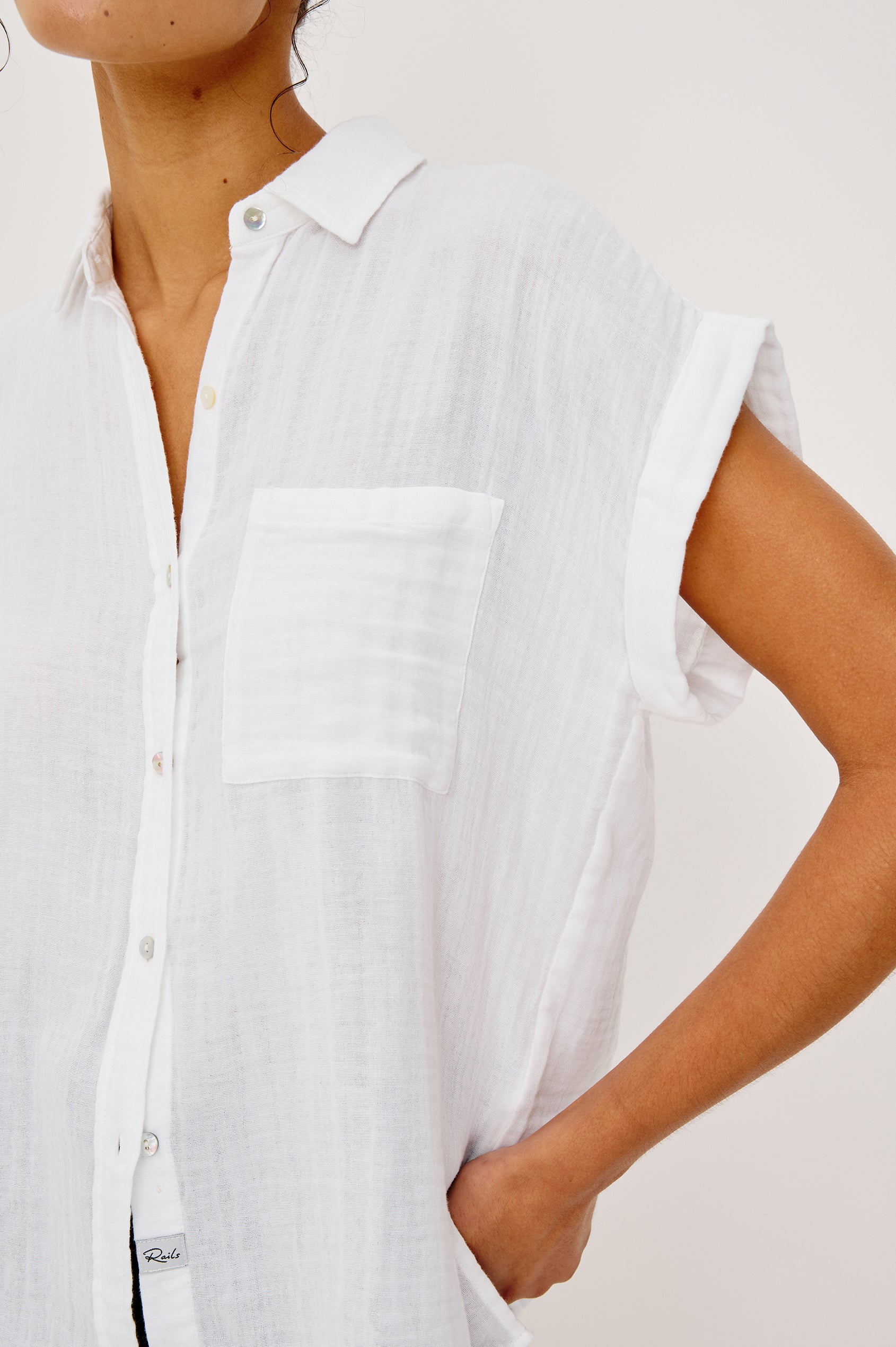 Whitney button front collared shirt with cuffed cap sleeve, features a chest pocket in white colorway. Front view featured on model
