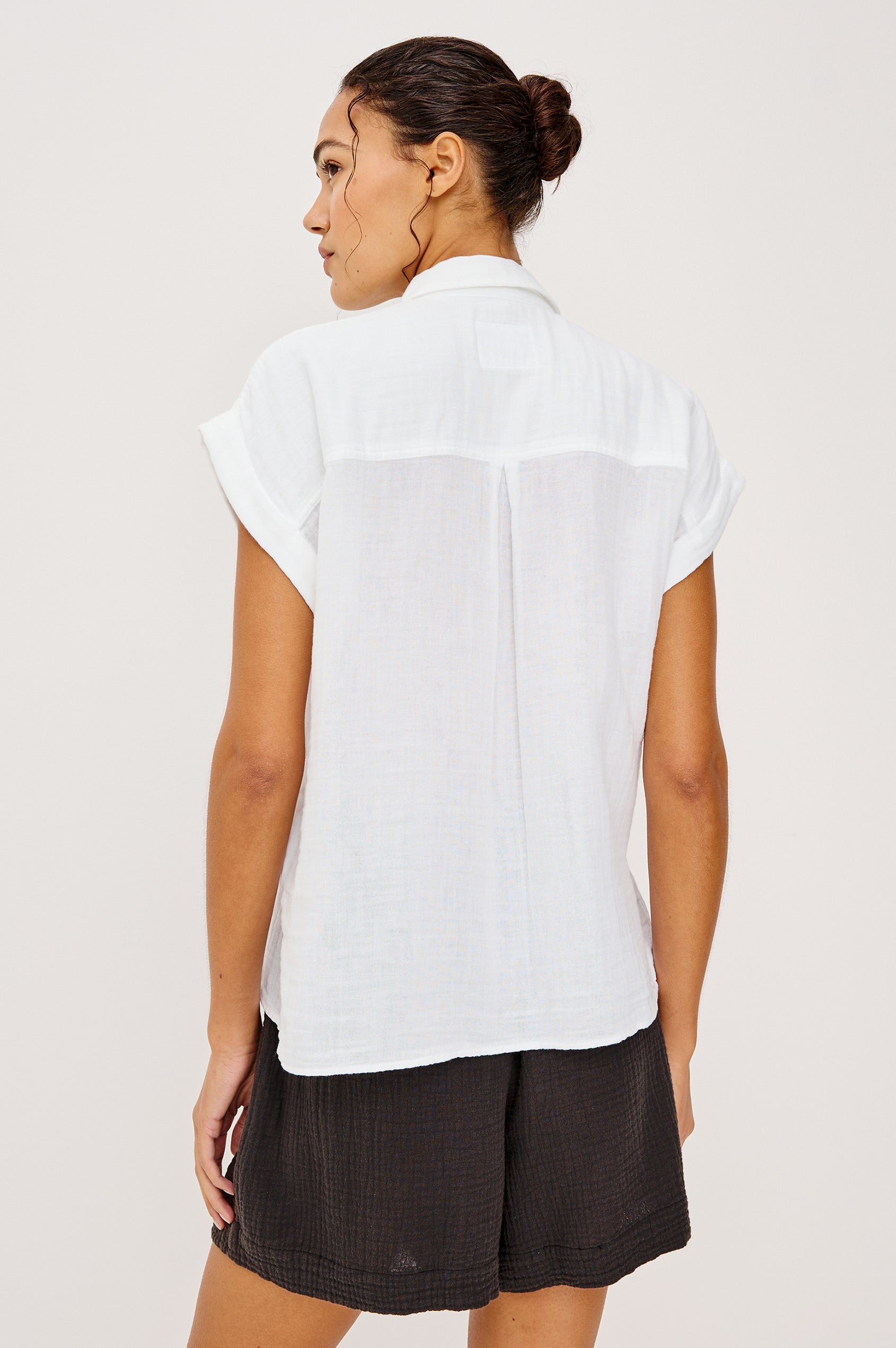 Whitney button front collared shirt with cuffed cap sleeve, features a chest pocket in white colorway. Front view featured on model