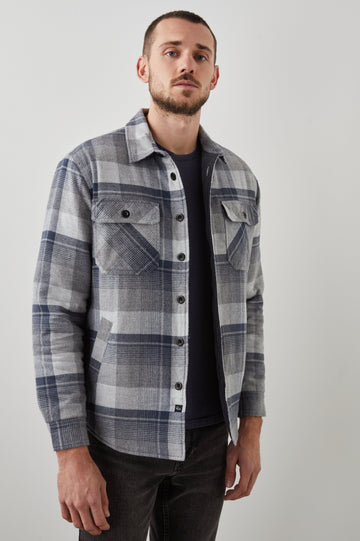 Worthing Jacket with Button Closure and two Chest Button Flap Pockets in Slate Mist Heather Colorway, a Grey and Blue Plaid - Front View Featured on Model