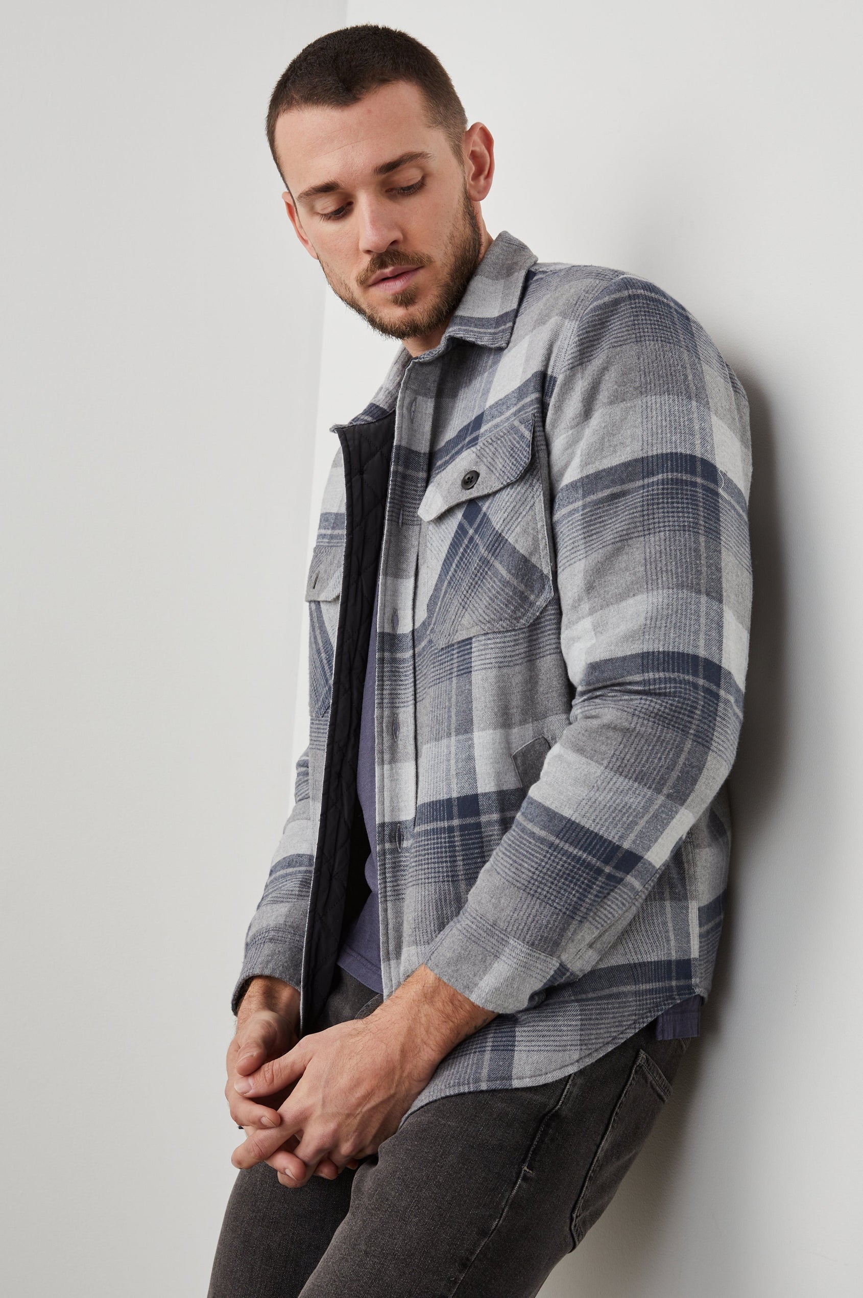 Worthing Jacket with Button Closure and two Chest Button Flap Pockets in Slate Mist Heather Colorway, a Grey and Blue Plaid - Side View Featured on Model