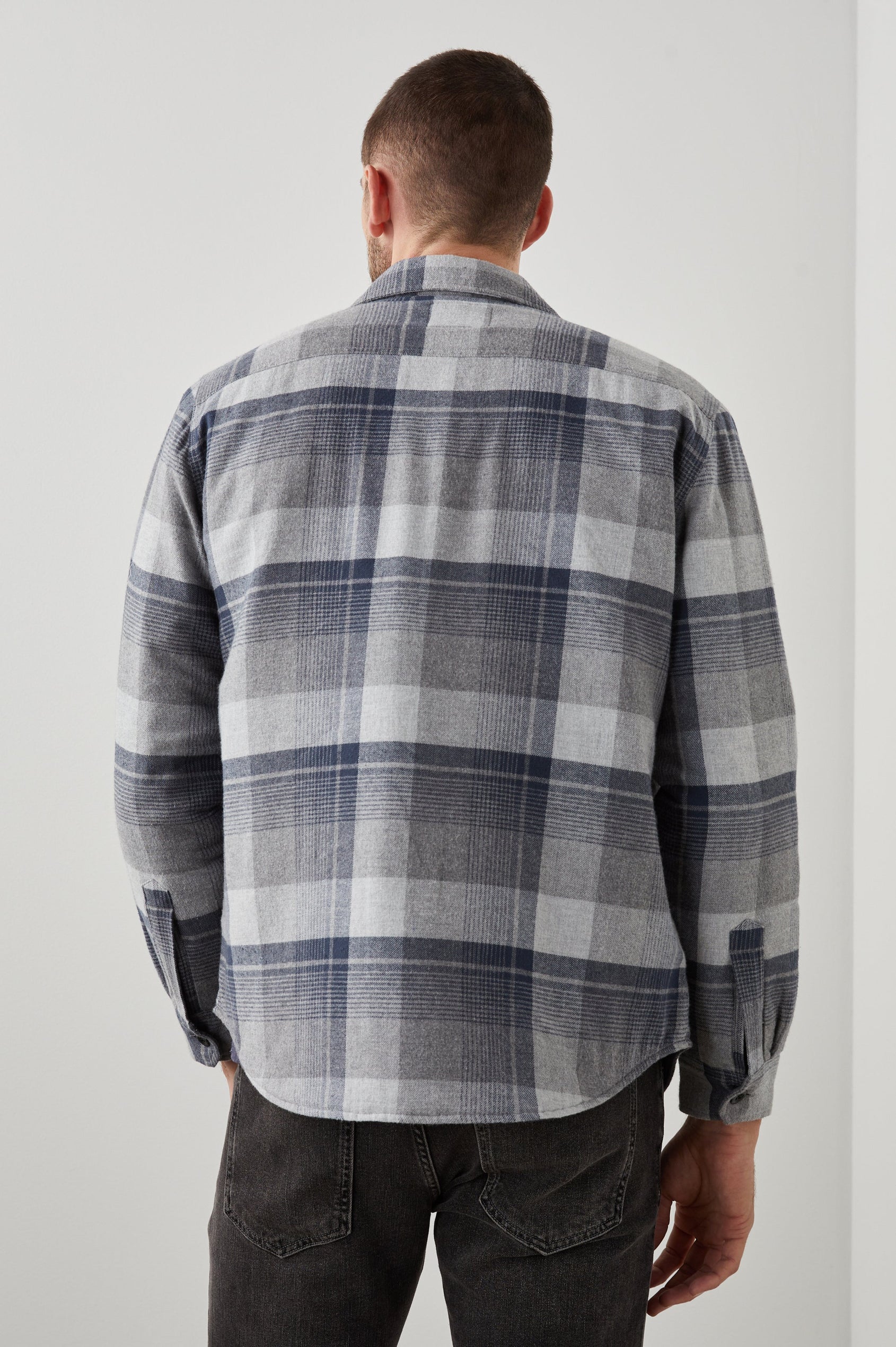 Worthing Jacket with Button Closure and two Chest Button Flap Pockets in Slate Mist Heather Colorway, a Grey and Blue Plaid - Back View Featured on Model
